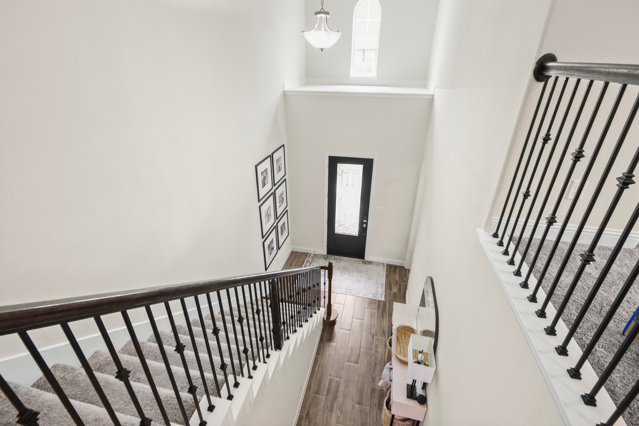 Desirable wrought iron balusters with stained wood handrail and wood stained Newel posts