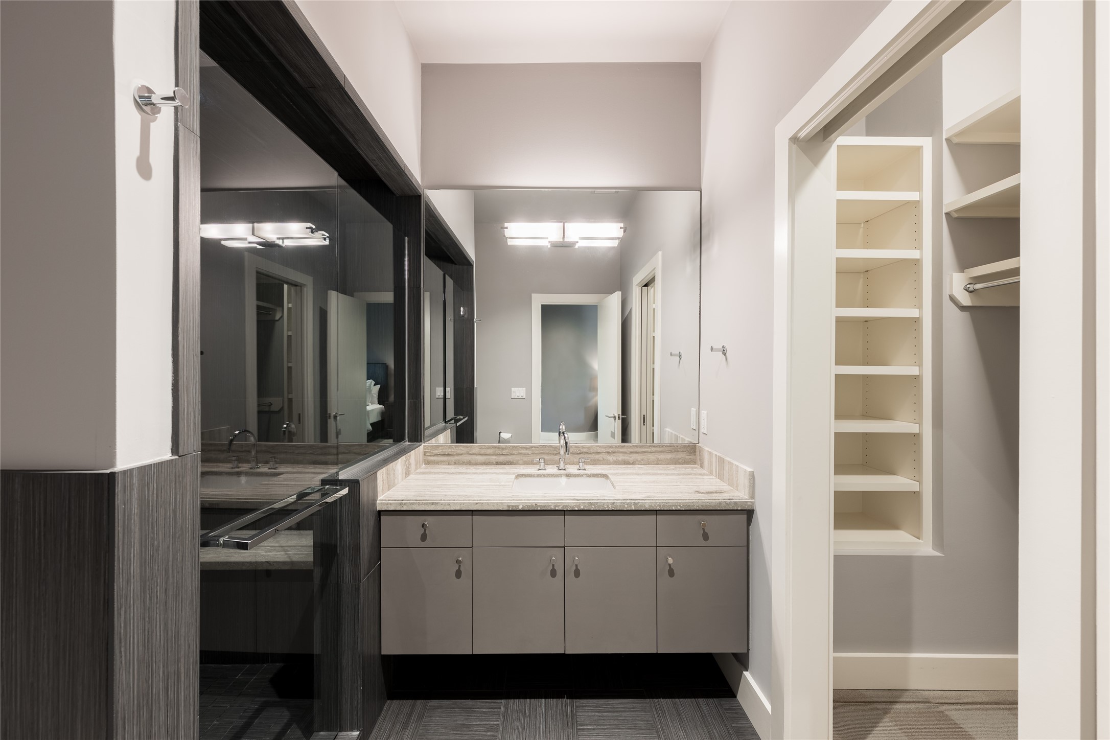 The second-floor guest suite includes a private full ensuite bath with a floating vanity, generous built-in storage and a walk-in shower, giving guests a fully self-contained space within their private wing.