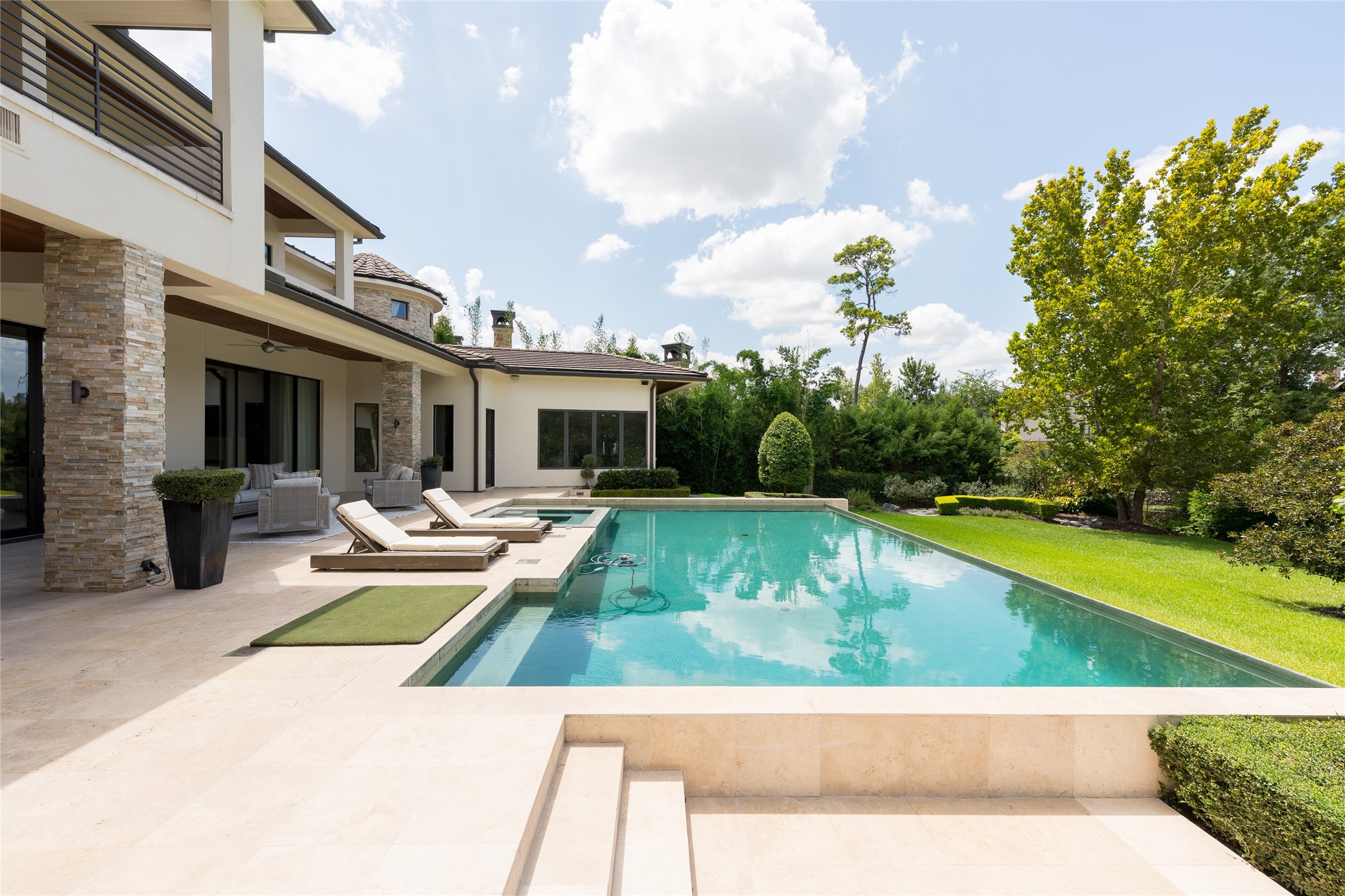 The heated infinity-edge pool is designed as the centerpiece of the outdoor setting, complete with an integrated spa and waterfall wall. Its position directly off the covered outdoor living areas creates an easy connection between the home, pool and expansive backyard.