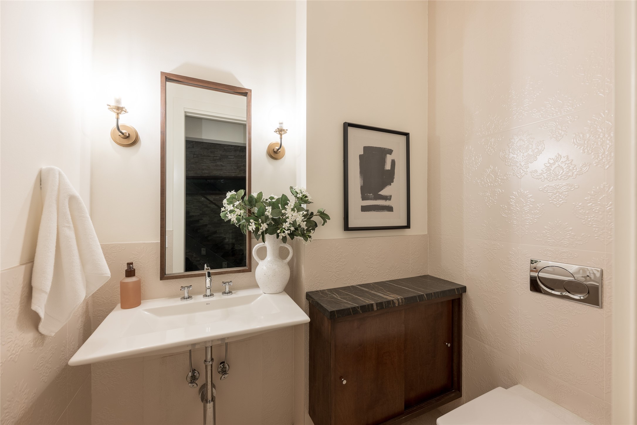 Located just beyond the foyer and before the kitchen, the first-floor powder room is conveniently positioned for guests without interrupting the homes primary living spaces. A floating vanity and vessel sink continue the clean, modern detailing found throughout the residence.