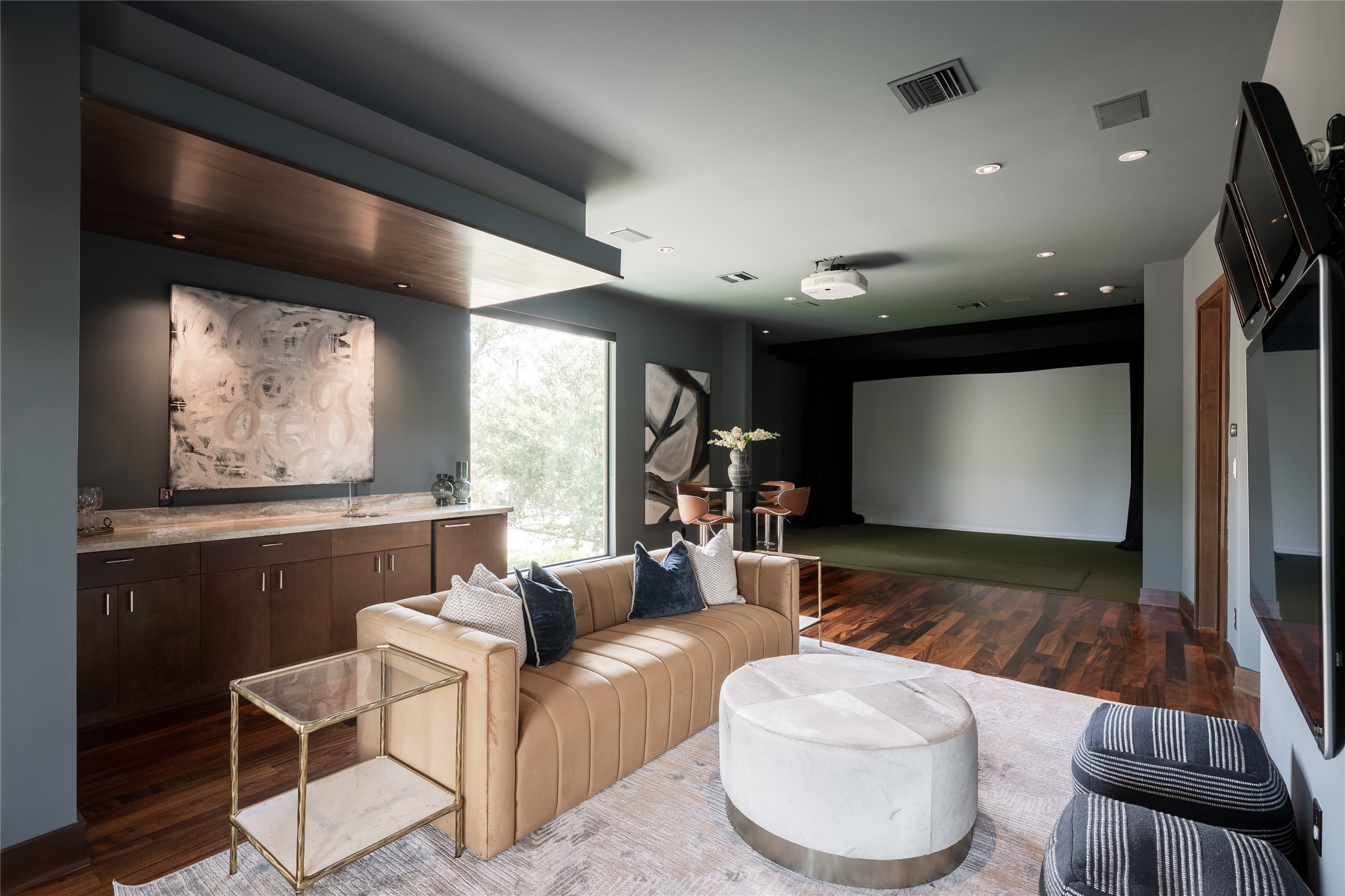 The upstairs game room is designed for entertaining, complete with a full golf simulator, wet bar and dedicated lounge area. Access from the homes rear staircase creates a separate route to the space without requiring guests to pass through the main upstairs wing.