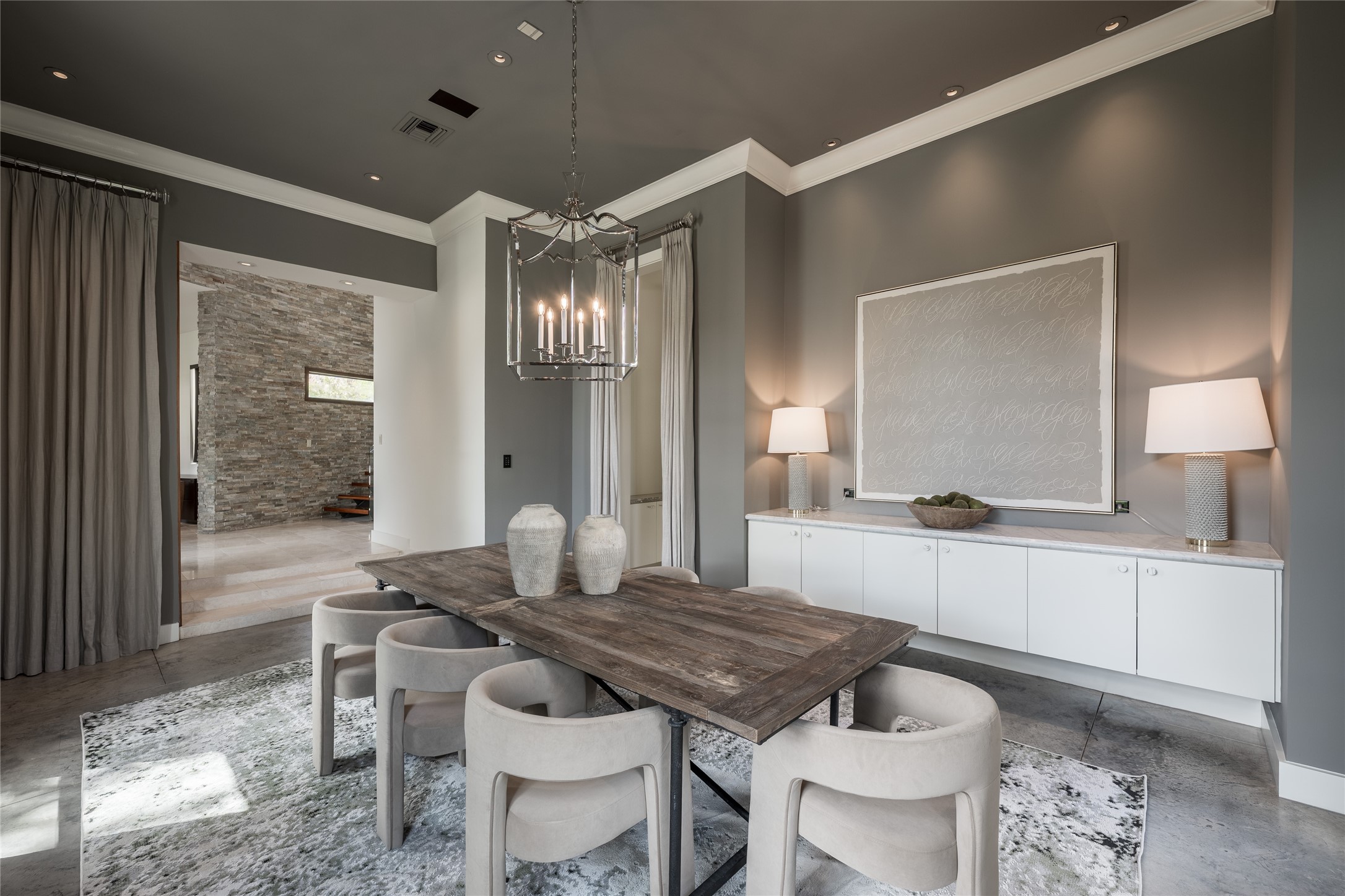 The generous proportions of the formal dining room allow it to accommodate an expansive table while still feeling open and uncluttered. Custom floating cabinetry provides a refined architectural element and functional storage without interrupting the rooms sense of scale.