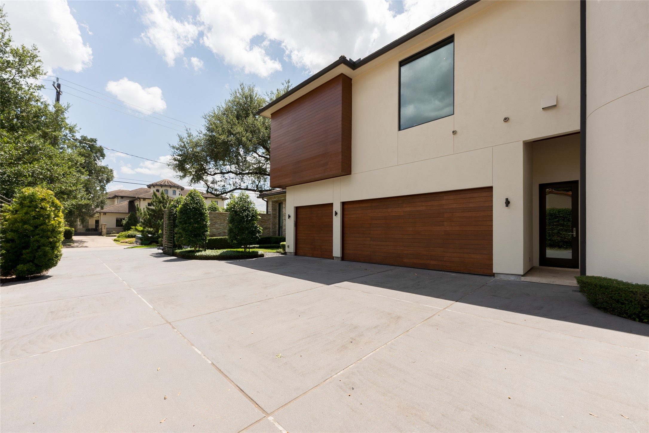 The property offers a dedicated guest parking area before the automatic gates, with the private motor court and 3-car garage positioned beyond. This two-stage layout provides substantial parking for guests while keeping the residence and main motor court privately secured.