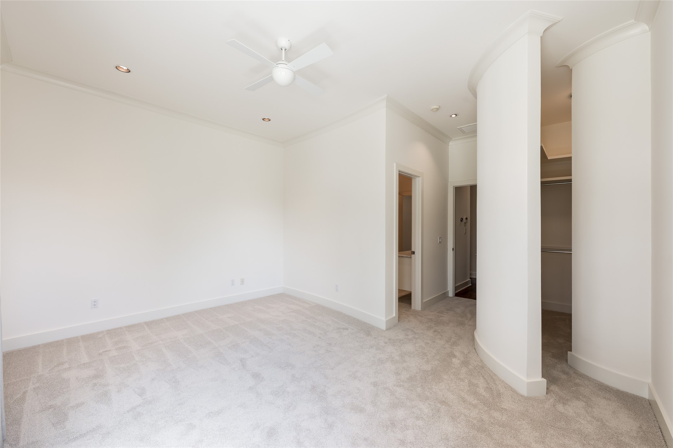 The first secondary bedroom is positioned near the main staircase on the second floor, offering generous proportions and a distinctive walk-in closet that extends beyond the traditional bedroom layout.