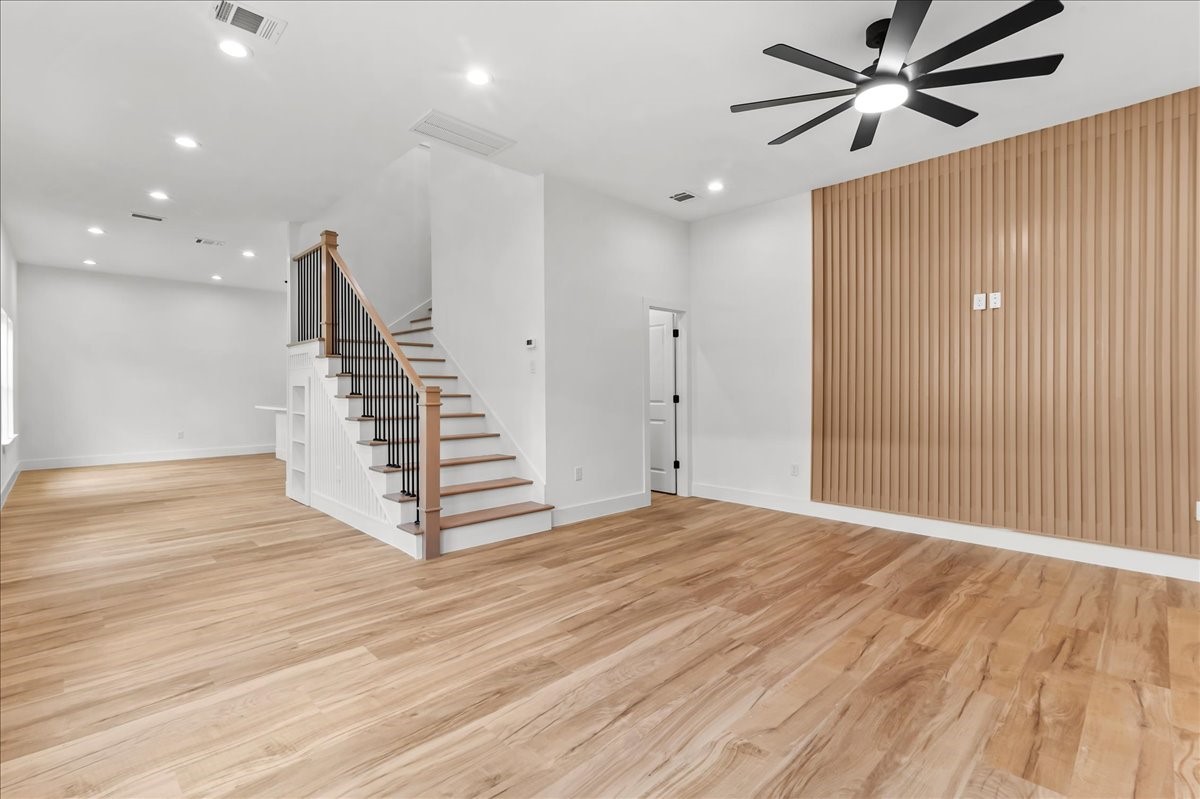 Unit B - Beautiful custom staircase featuring natural wood treads, sleek black iron balusters, and elegant white wainscoting. A perfect blend of modern design and timeless craftsmanship, creating a stunning focal point in the home. Accent Wall design may vary. Pictures are from a previous build.