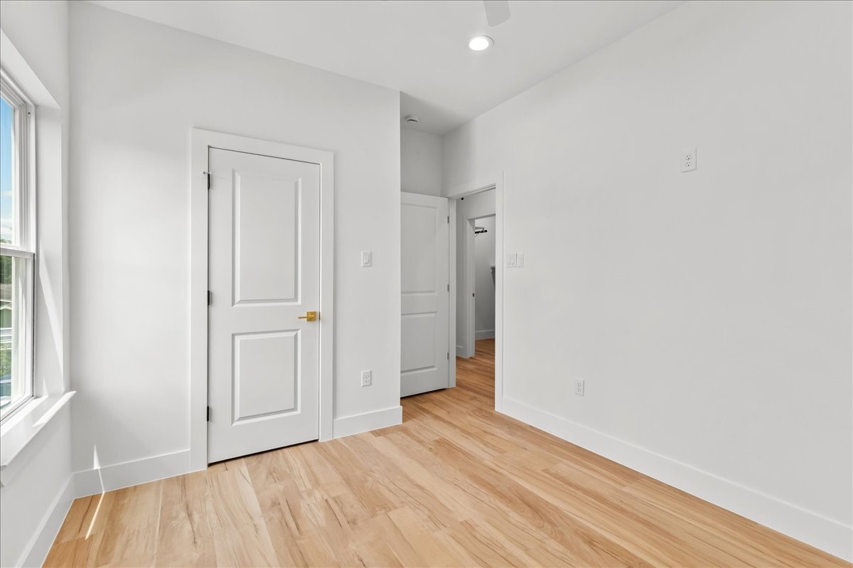 Unit A - The secondary bedroom offers a bright and comfortable space with ample room for family, guests, or a home office.