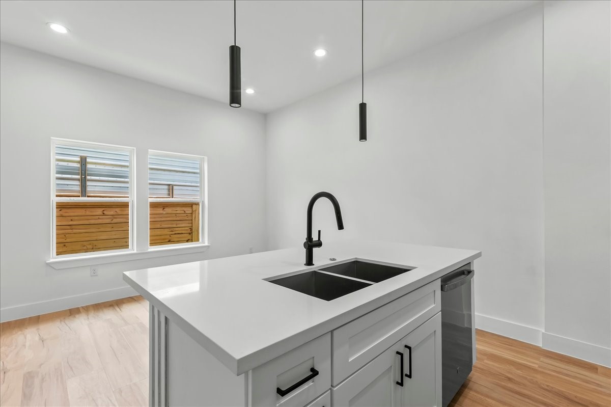 Unit B - The spacious kitchen island serves as the centerpiece of the home, offering a seamless view of the dining area and large windows that fill the space with natural light.