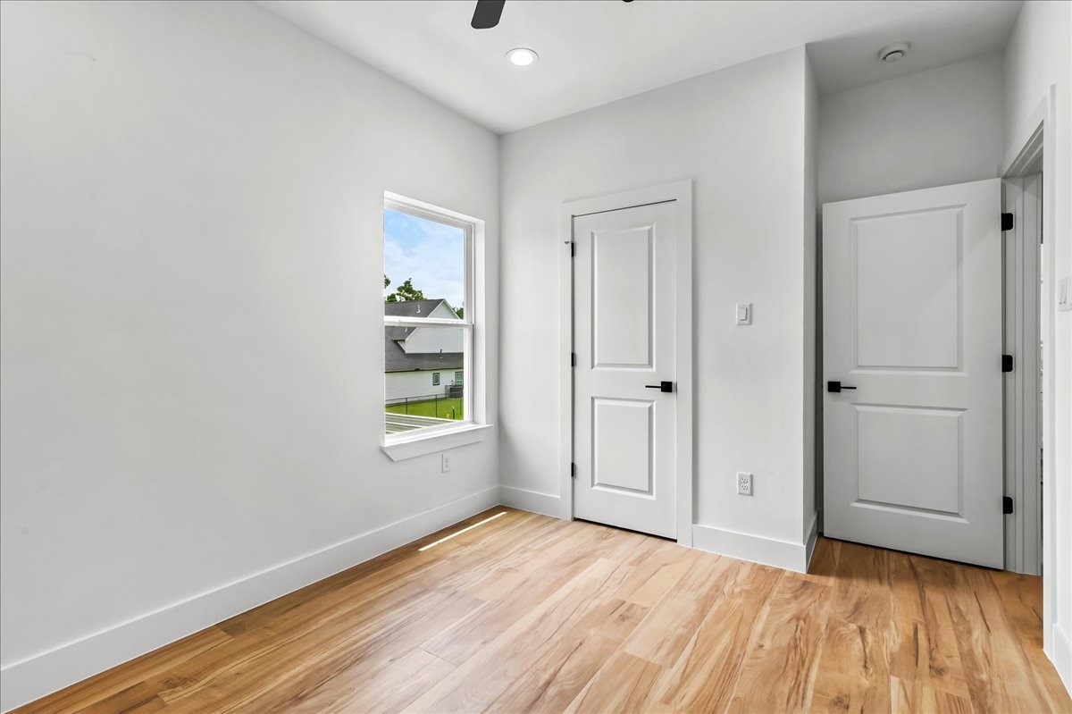 Unit B - The secondary bedroom offers a bright and comfortable space with ample room for family, guests, or a home office.