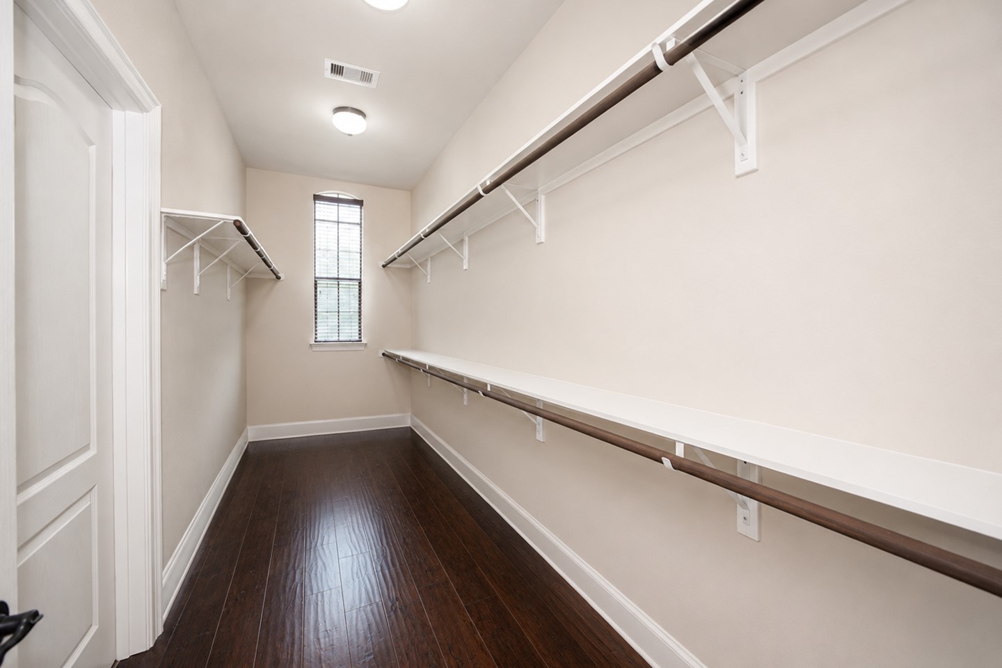 Primary closet - Virtually enhanced image. Personal items have been removed to demonstrate the closets full storage potential.