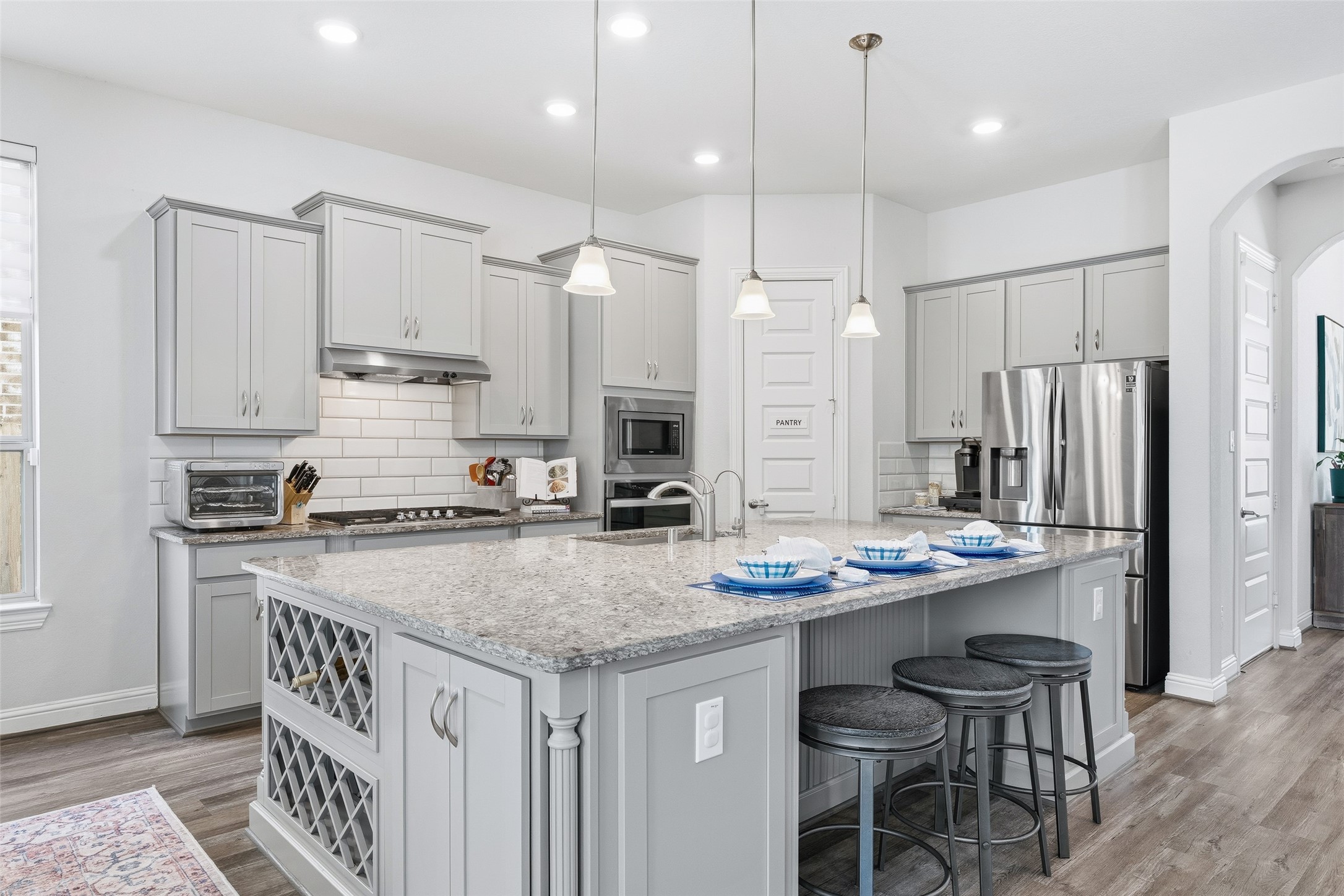 Move freely in this spacious chefs kitchen, featuring stainless steel appliances and a five-burner stove for effortless meal preparation. Expansive granite countertops provide plenty of room for prepping and serving, while the generous breakfast bar offers additional seating for casual dining and gathering.