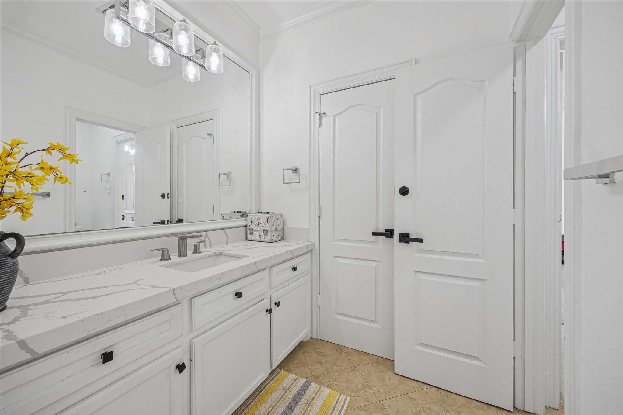 One of 2 upstairs adjoining jack and jill bathrooms. Bright and clean bathroom featuring a large mirror, sleek modern fixtures, and a spacious vanity with a quartz countertop.