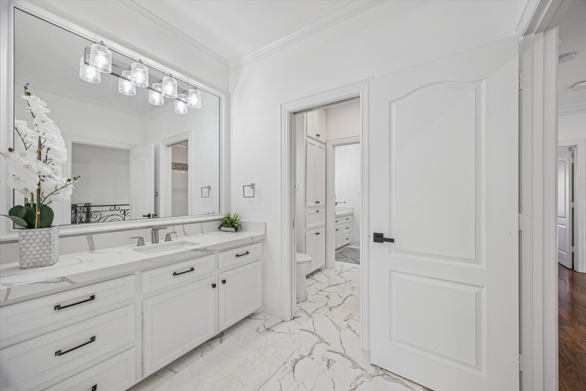 One of 2 upstairs adjoining jack and jill bathrooms. Bright and clean bathroom featuring a large mirror, sleek modern fixtures, and a spacious vanity with a quartz countertop.