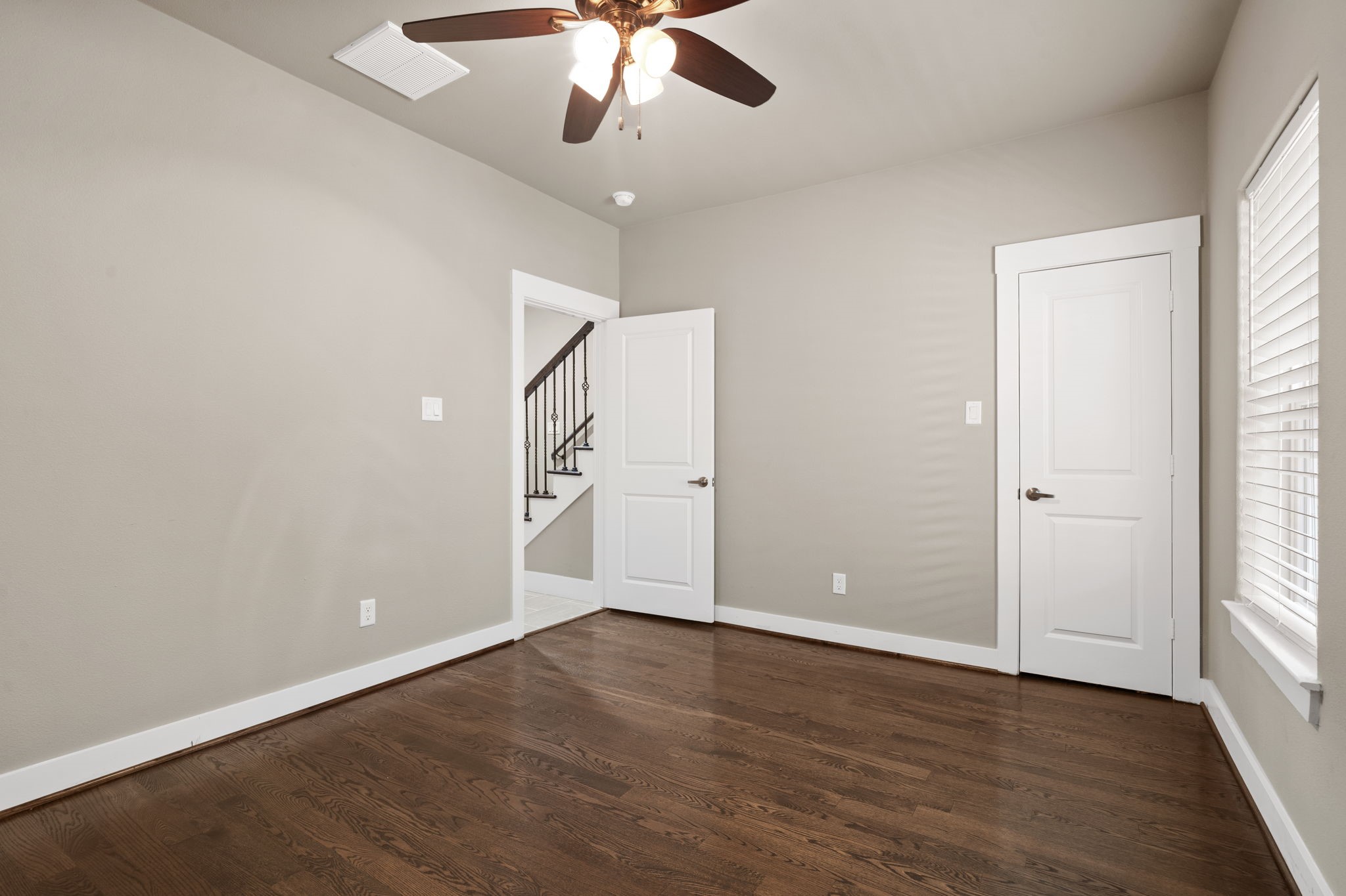Alternate view of the first-floor bedroom showcasing the entrance and walk-in closet. This versatile room offers endless possibilities and can be tailored to fit your lifestyle as a private guest suite, home office, workout space, or any other use that suits your needs.