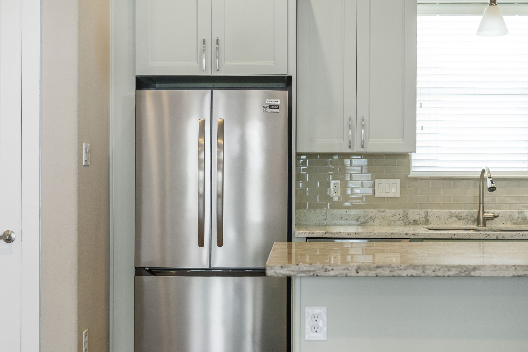 A large window above the sink fills the kitchen with soft natural light while offering a bright and inviting workspace.