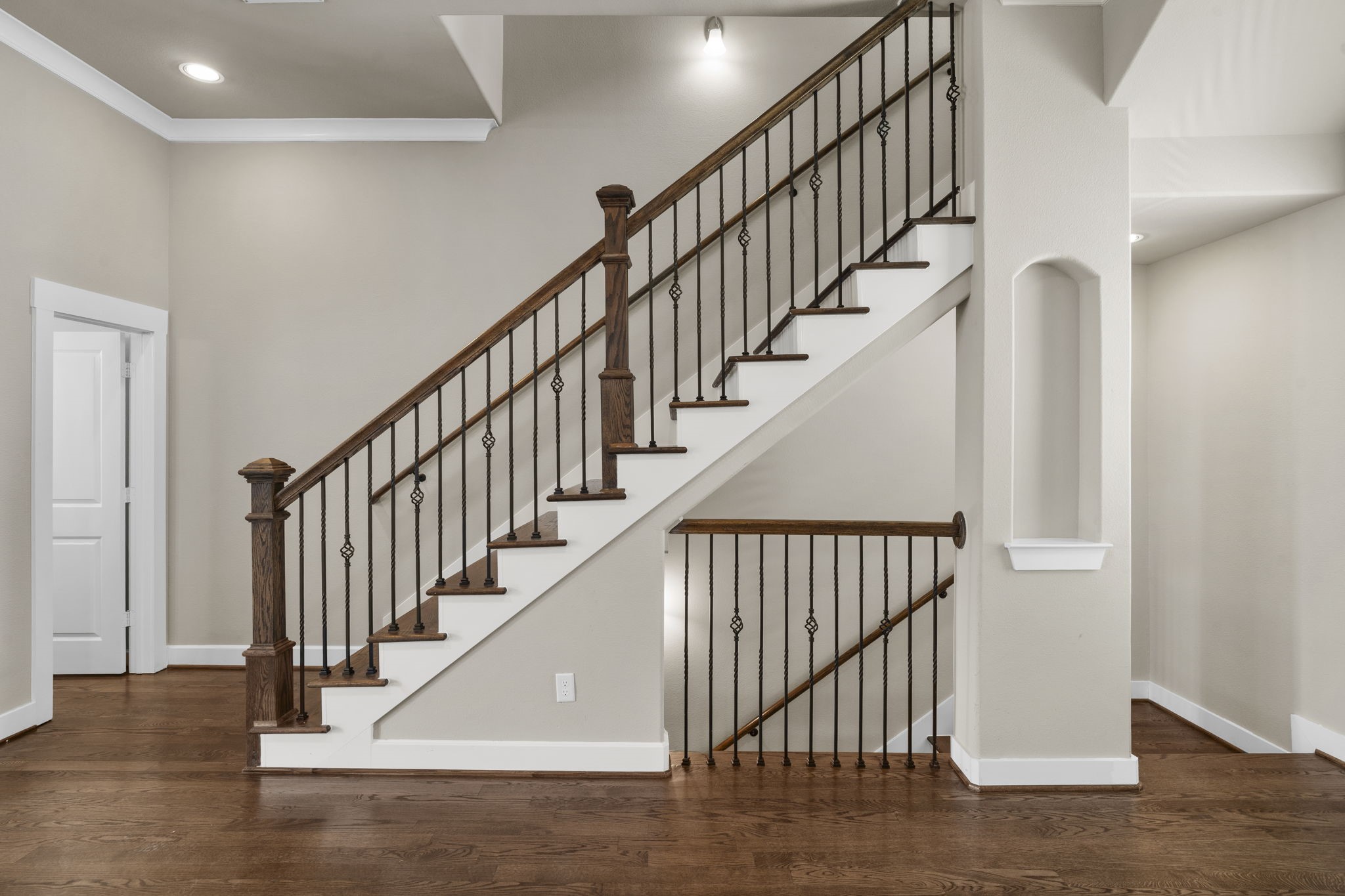 Classic solid oak stairs, complemented by a custom railing and wrought-iron spindles, create an elegant architectural focal point in the home.