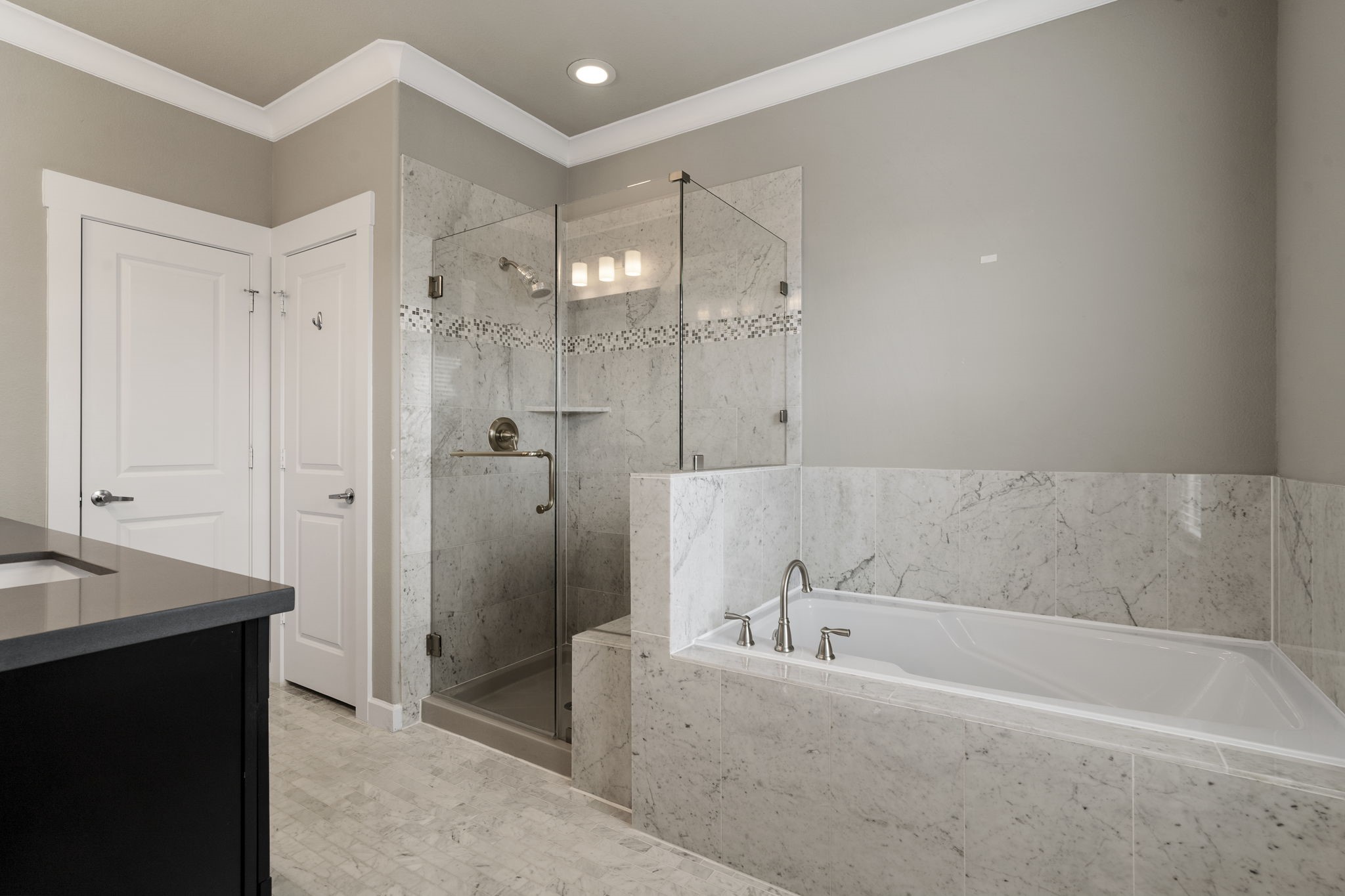The spa-inspired primary en suite bath features dual vanities, a soaking tub, a walk-in shower, linen closet, and a large walk-in closet.