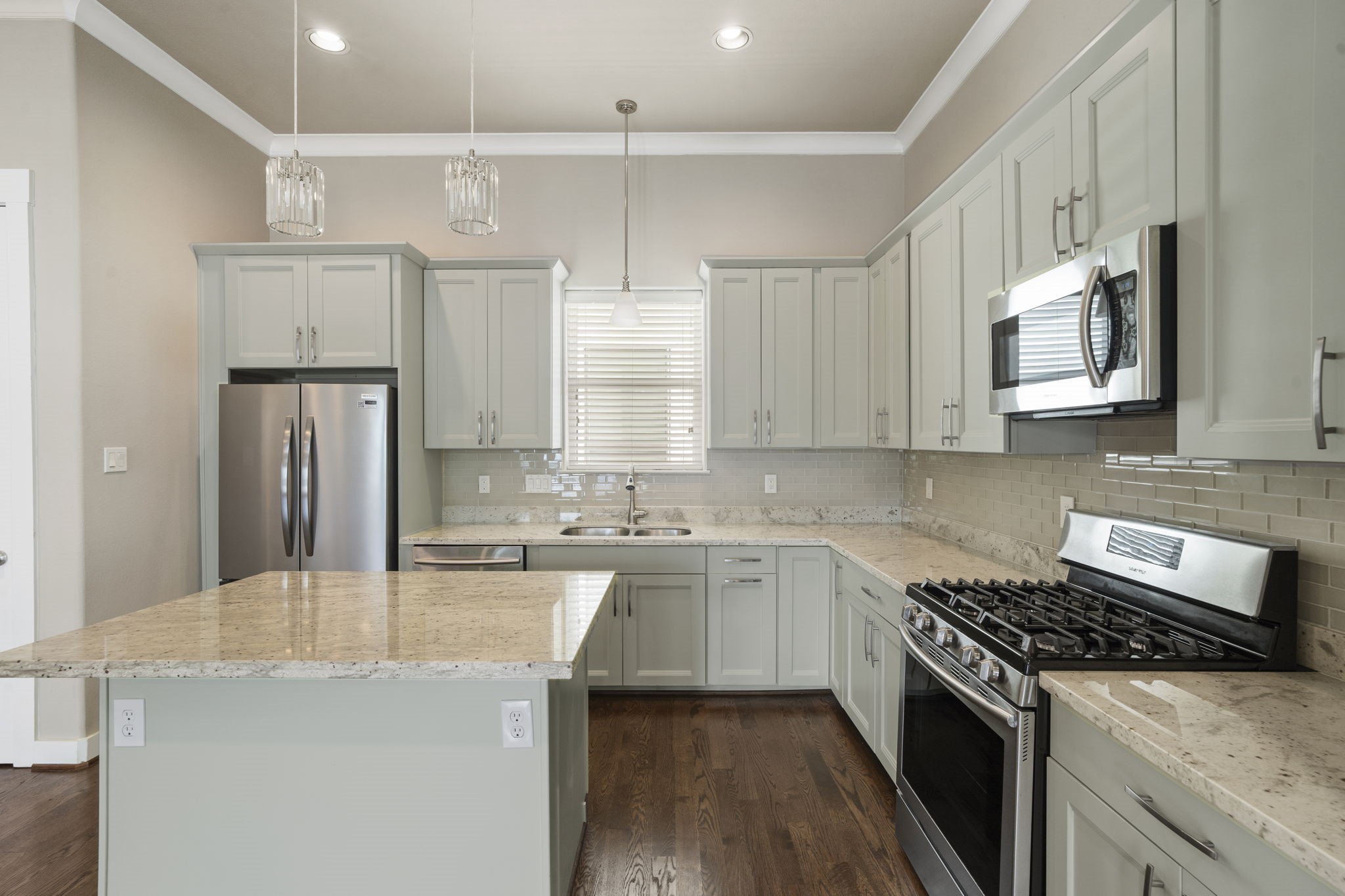 The stunning island kitchen boasts a gas range, pantry, breakfast bar, beverage refrigerator, abundant cabinetry, and generous counter space.