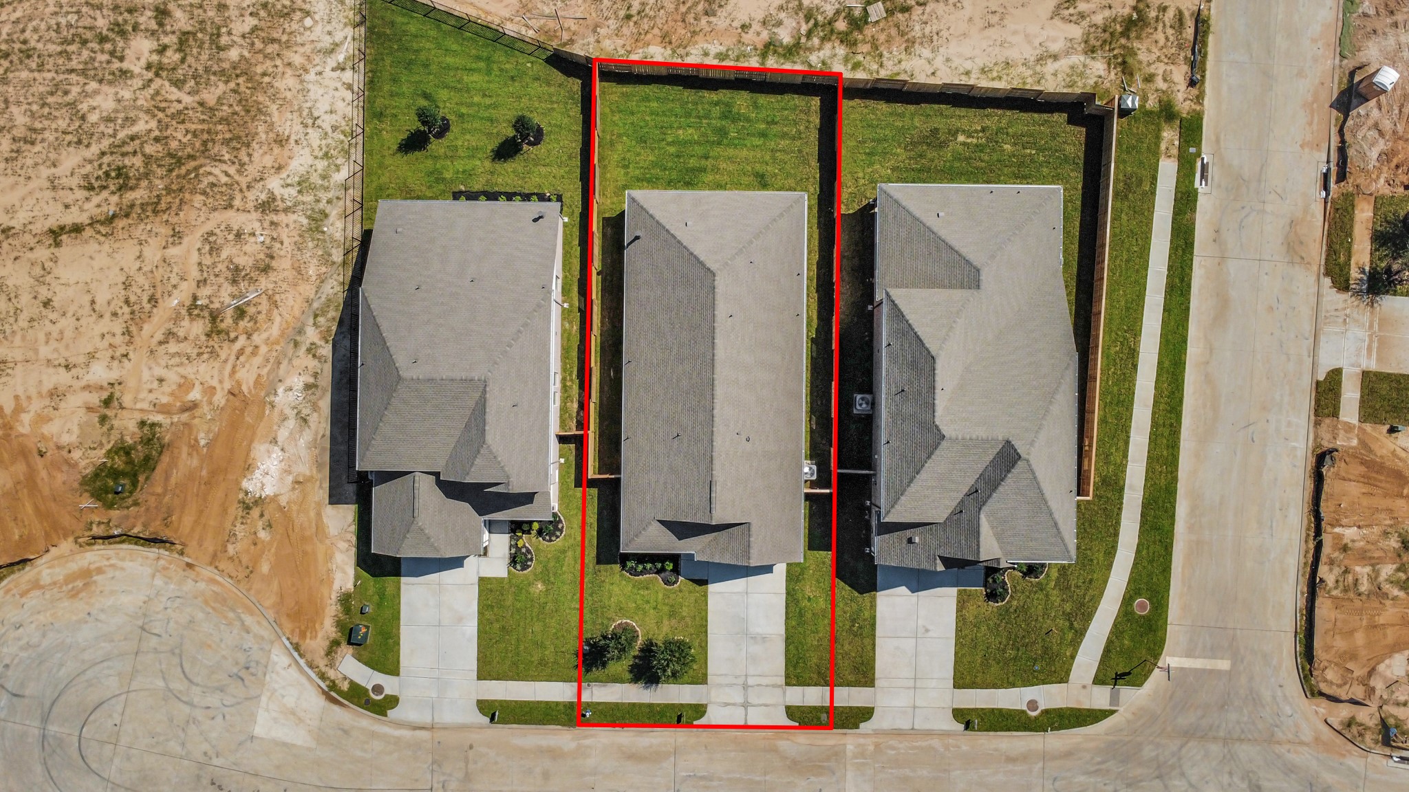 An aerial view of a spacious subdivision lot, highlighting a well-maintained yard and a fully fenced perimeter, offering both privacy and expansive outdoor space.