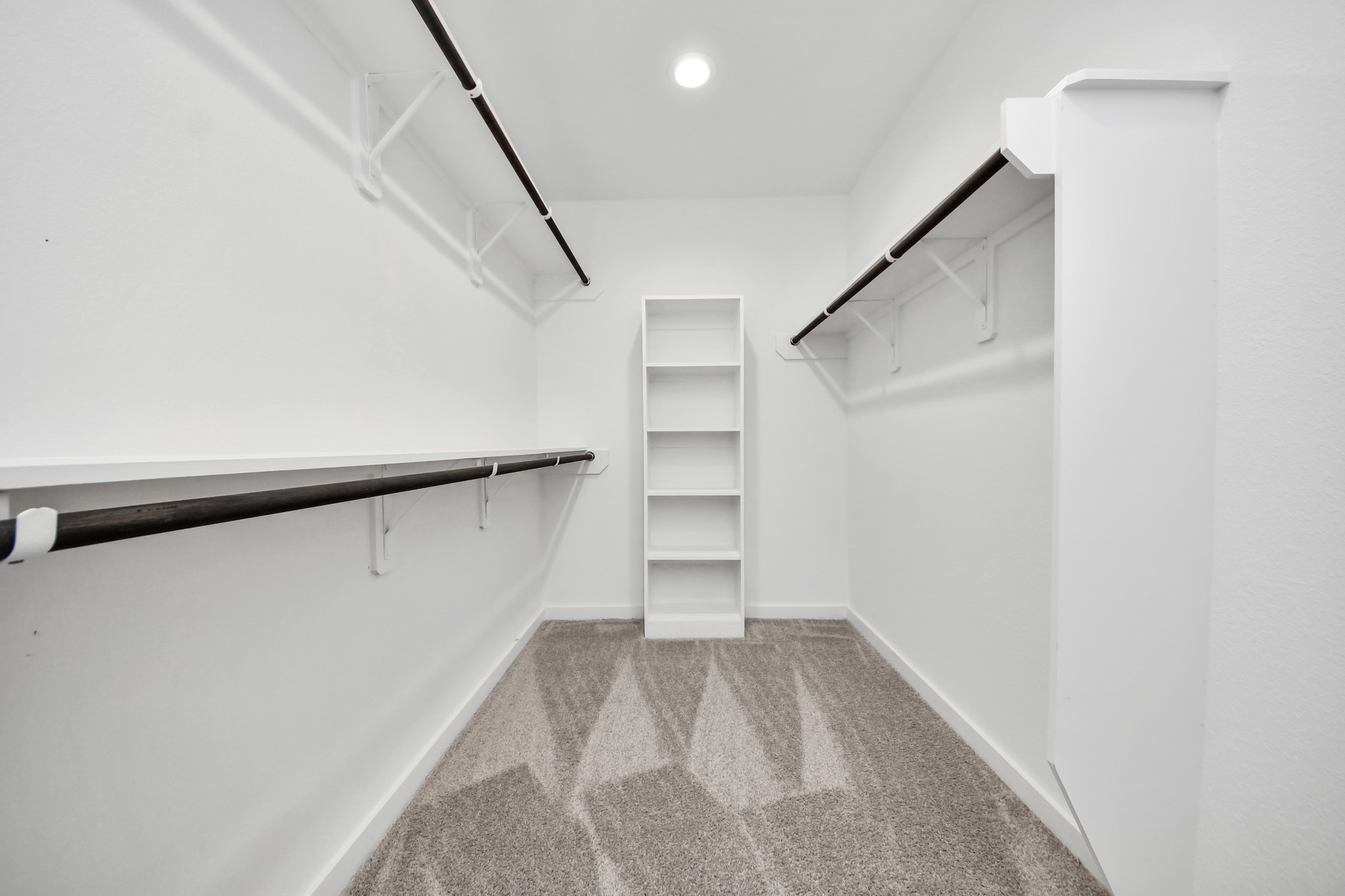 Walk-in closet that epitomizes luxury and practicality. This generously sized space features built-in shelving, offering abundant room for impeccable organization. High ceilings and recessed lighting create a bright and welcoming ambiance.