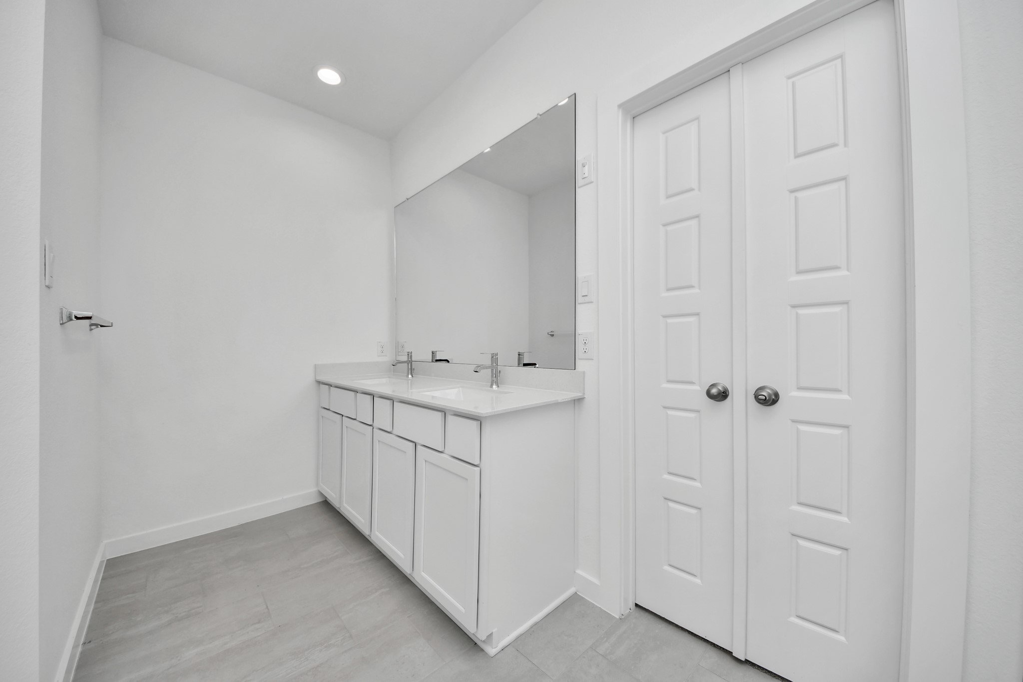 Elevate your daily routine at the elegant vanity, now equipped with double sinks, light countertops, modern hardware, and beautiful recessed lights.