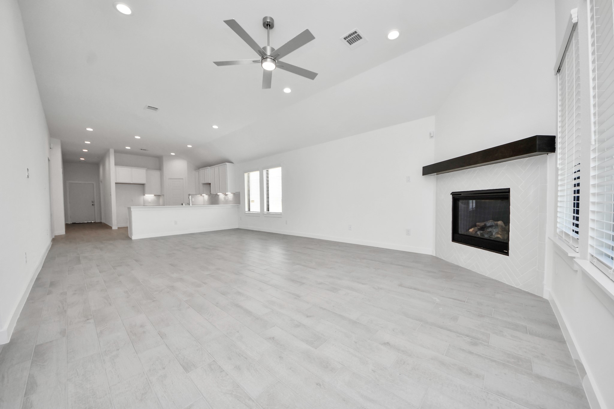 Gather the family and guests together in your lovely living room! Featuring soaring high ceilings, recessed lighting, ceiling fan, custom paint, gorgeous floors, and large windows that provide plenty of natural lighting throughout the day.