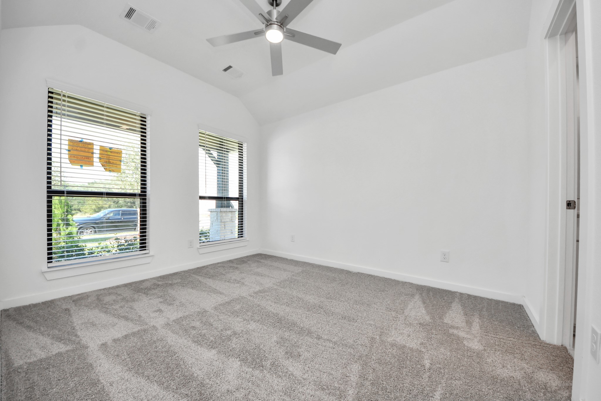 Secondary bedroom features plush carpeting, large windows that let in plenty of natural light, bright paint, and spacious closets.