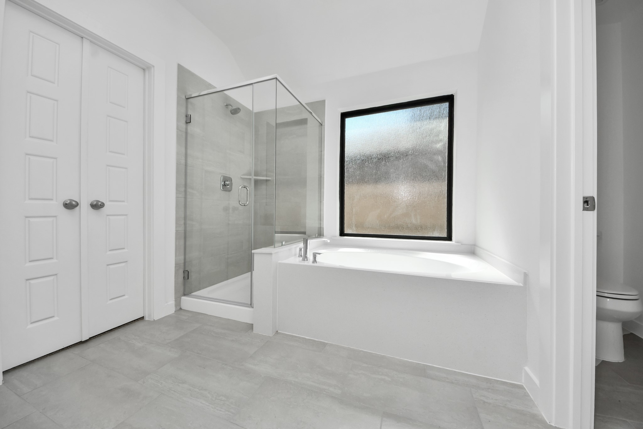 Indulge in a spa-like retreat within the confines of this primary bathroom. Delight in a spacious walk-in shower enveloped in stylish tile surround, unwind in a separate garden tub adorned with custom detailing.
