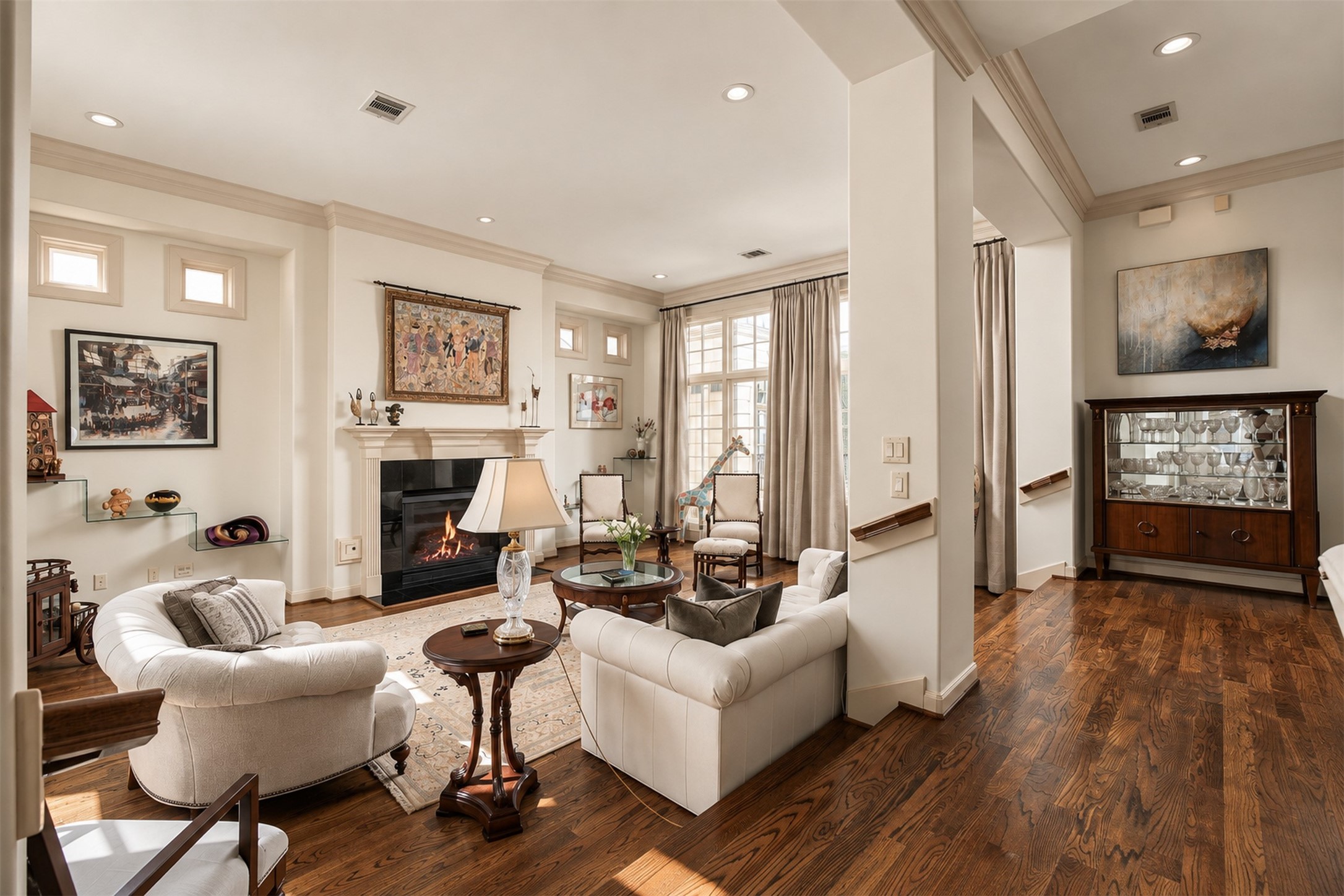 Arriving on the second floor, the home opens dramatically into its main living spaces, where tall windows, generous ceiling height and a fireplace establish an immediate sense of scale. **Rendering of neutral wall color**