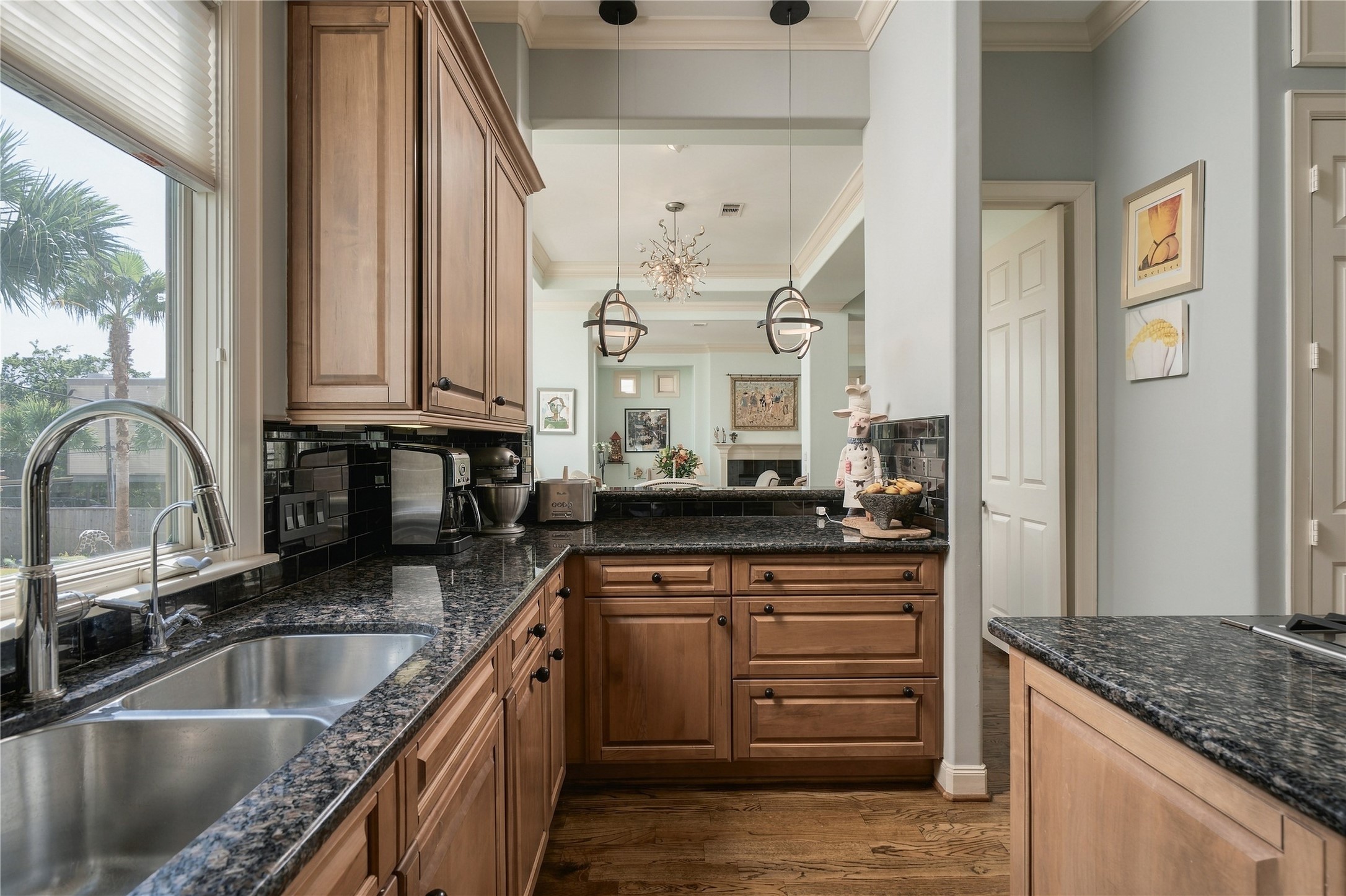 A pass-through keeps the kitchen visually connected to the dining and living rooms beyond, allowing light and conversation to move between each space.