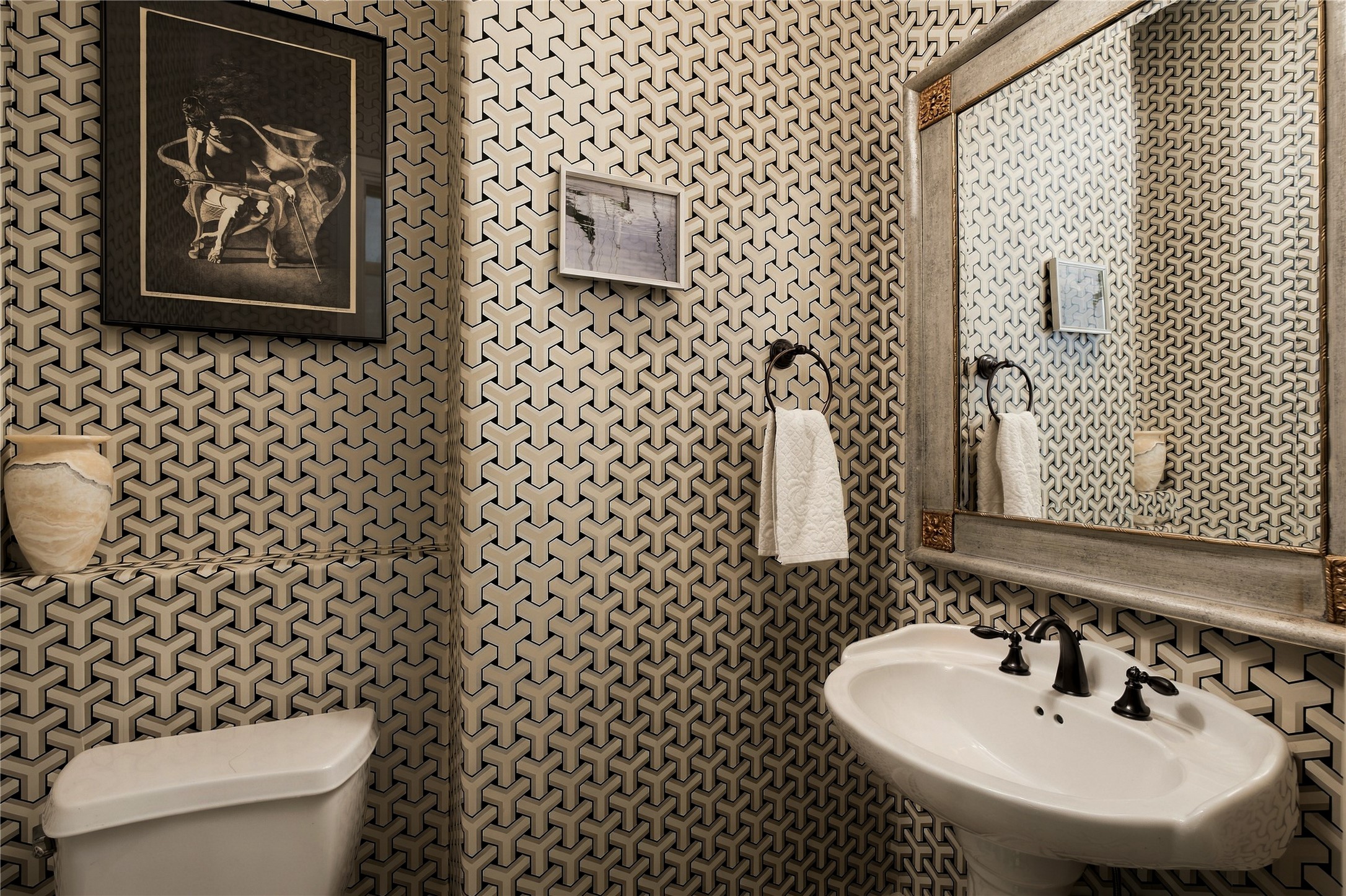 A little unexpected personality along the way; the powder room trades the homes softer palette for bold geometric wallcovering and dark contrasting fixtures.