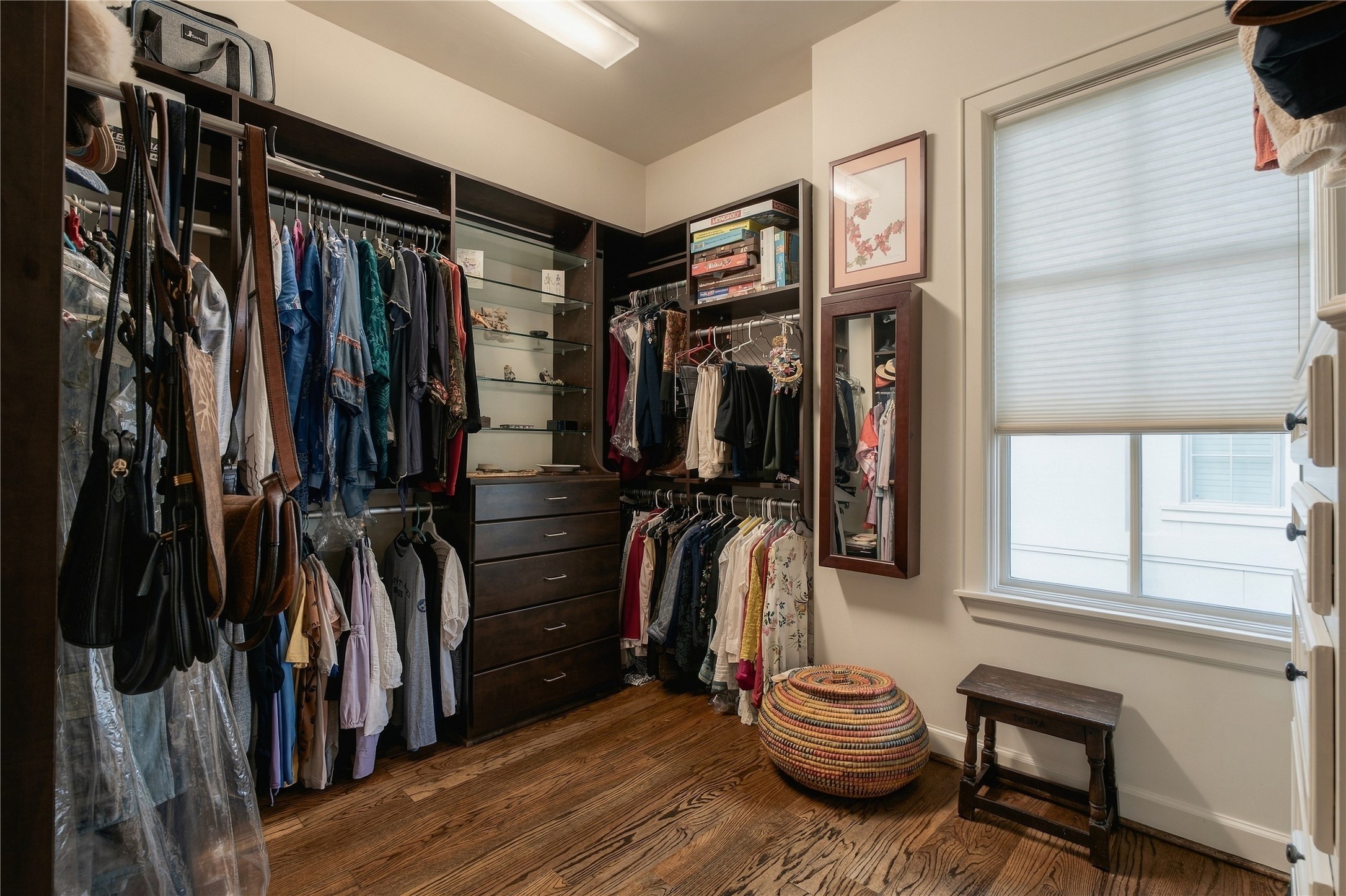 A spacious primary walk-in closet offers custom built-in organization with plenty of room for wardrobe storage.