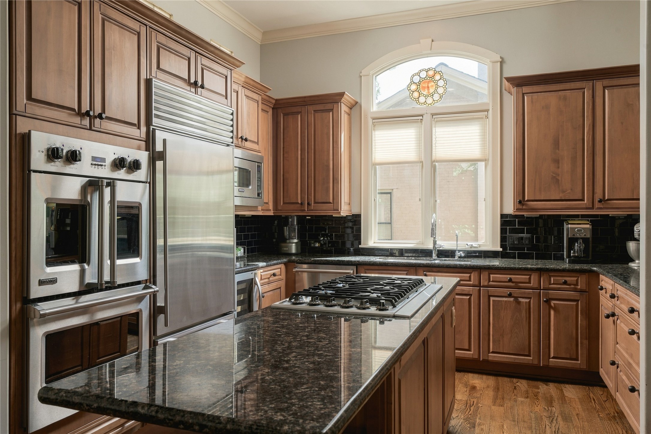 The appliance wall is anchored by a Viking double French-door oven and Sub-Zero refrigerator, seamlessly integrated into the surrounding cabinetry.