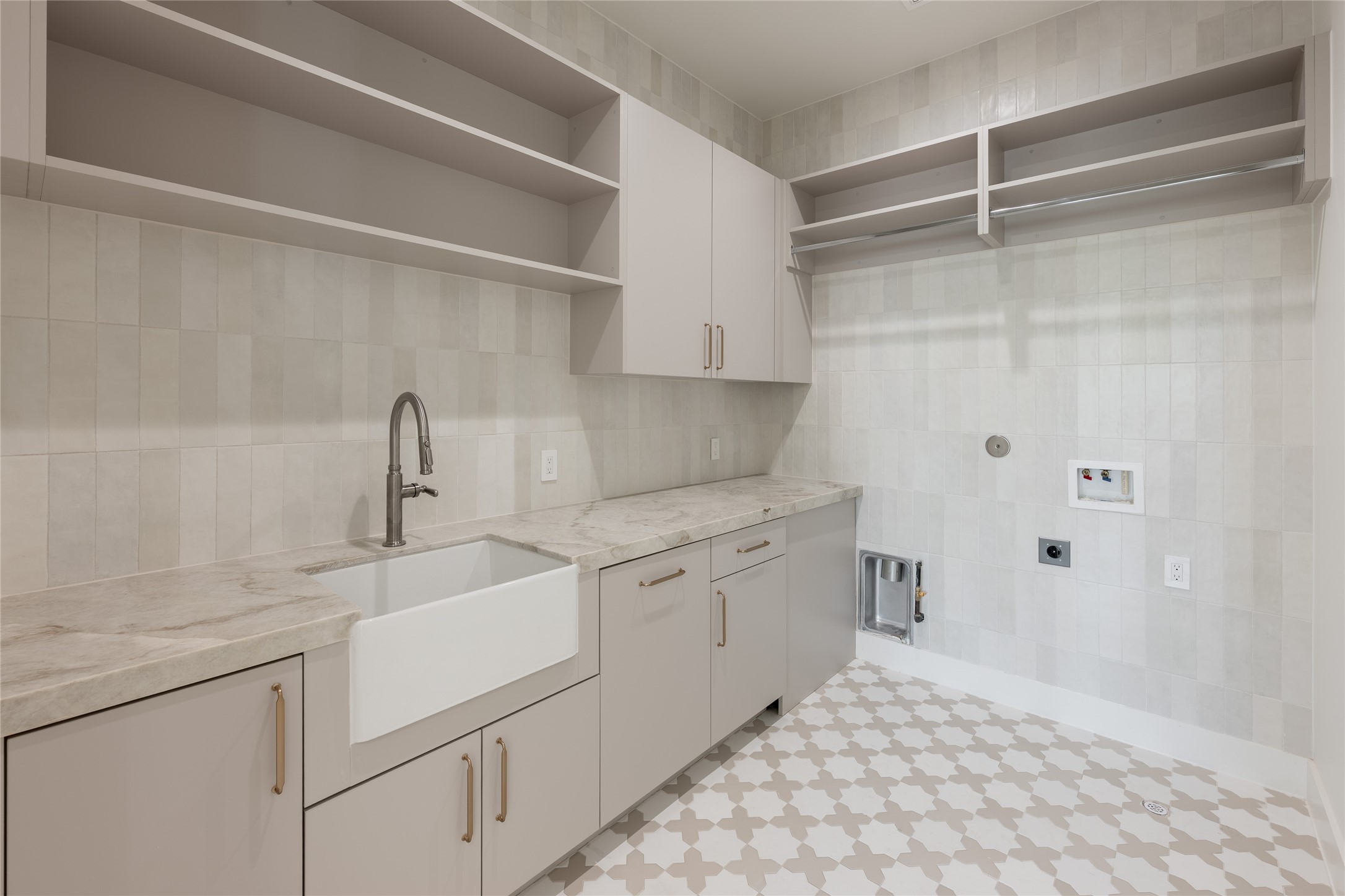 The utility room pairs generous built in storage with a dedicated sink and expansive counter space, bringing the same attention to function and finish into one of the homes hardest working spaces.