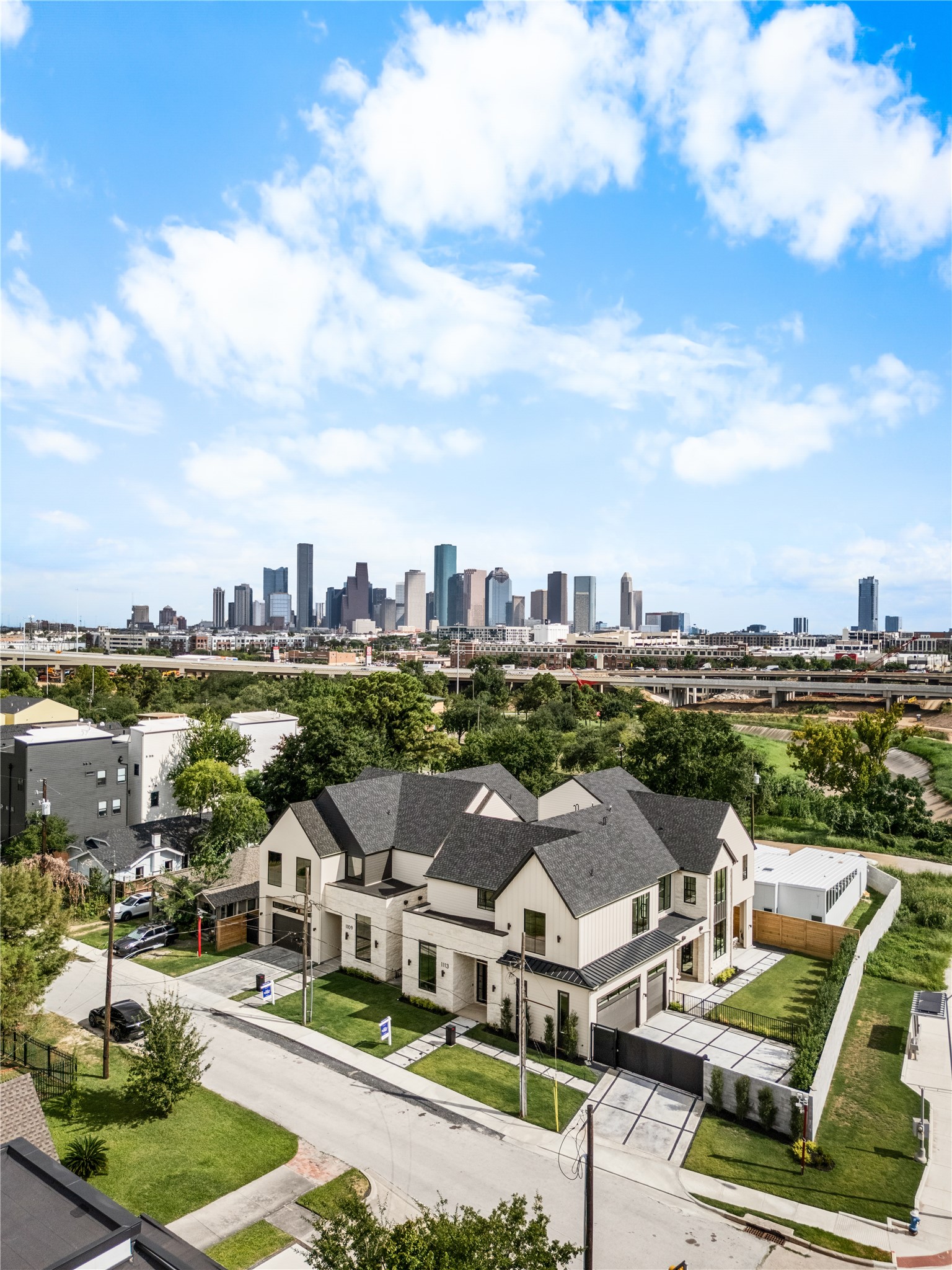The Saturn Residence enjoys a striking Houston backdrop, with the Downtown skyline rising prominently beyond the surrounding neighborhood.