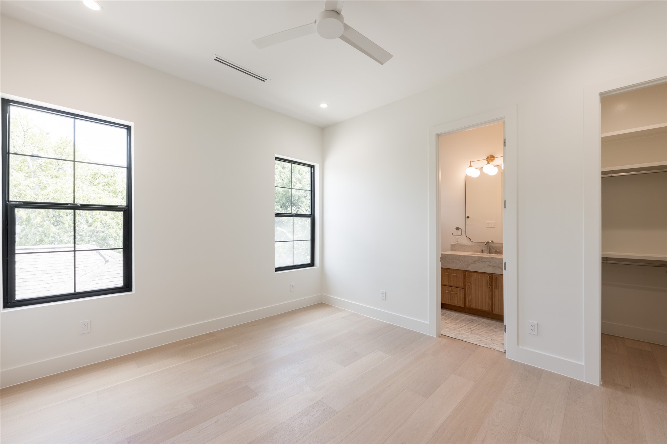 Another secondary bedroom offers generous proportions, abundant natural light and direct access to its ensuite bath, giving each bedroom a true sense of privacy.