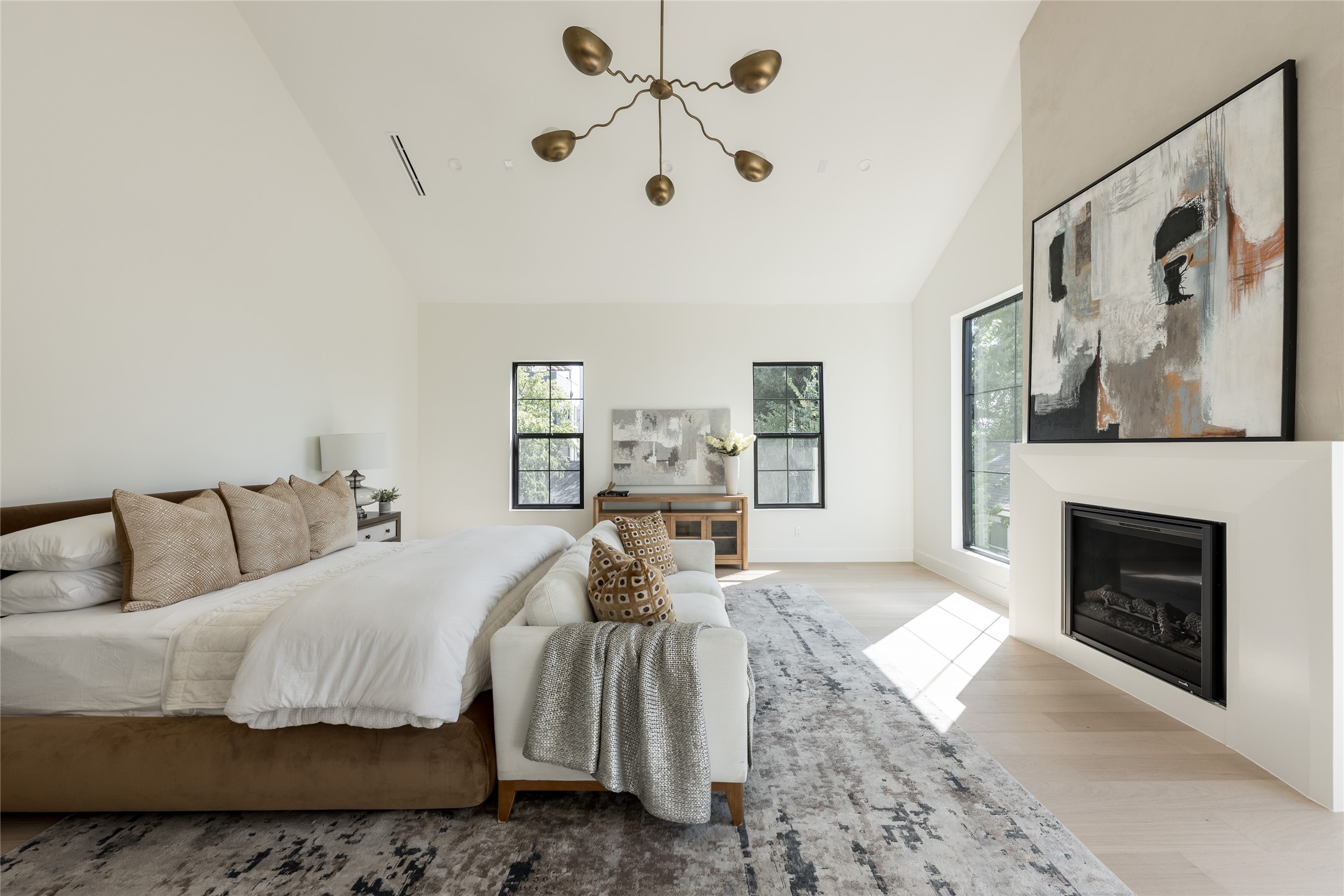 The expansive primary suite is defined by a soaring cathedral ceiling and fireplace, with enough scale to create a separate sitting area without compromising the sense of retreat.