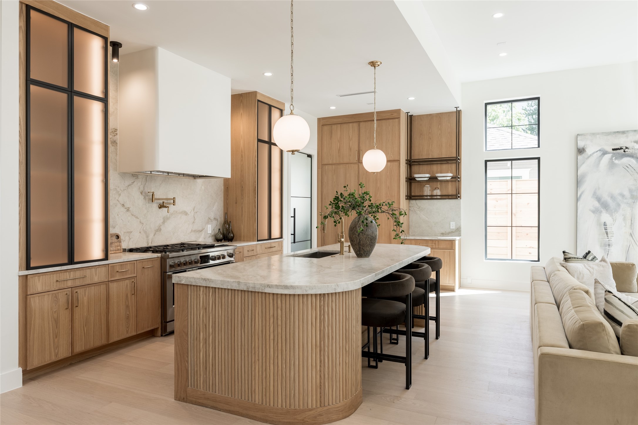 The oversized island anchors the kitchen with generous prep and gathering space, while the full butlers pantry sits discreetly beyond, keeping additional prep, storage and cleanup out of the main view.