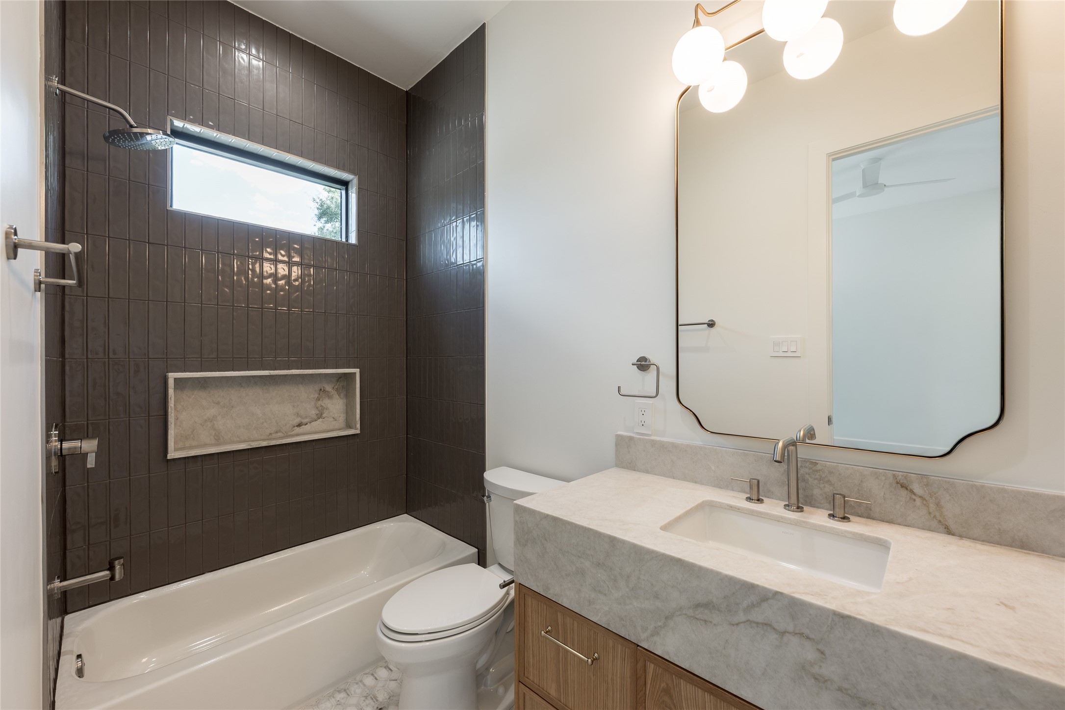 The secondary ensuite continues the homes refined finish palette with natural stone surfaces, designer tile and a glass enclosed tub and shower, giving guests a private bath of their own.