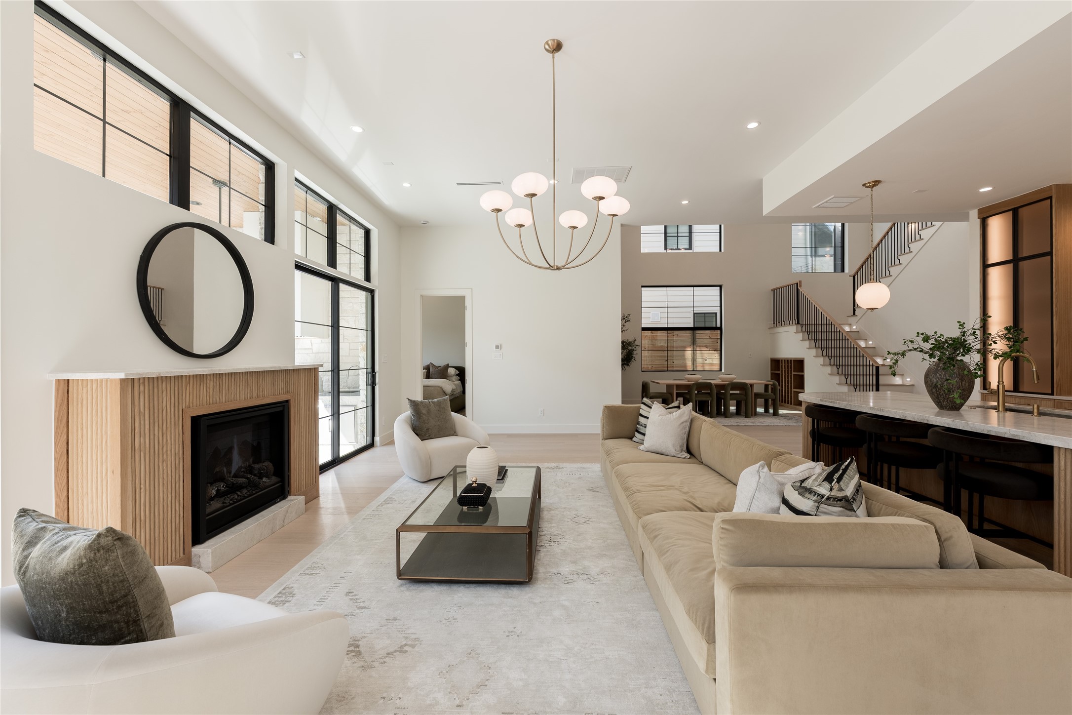 The great room brings the homes architecture into one frame, with 12 foot ceilings, a statement fireplace and an open connection to the kitchen and dramatic two story dining room beyond.
