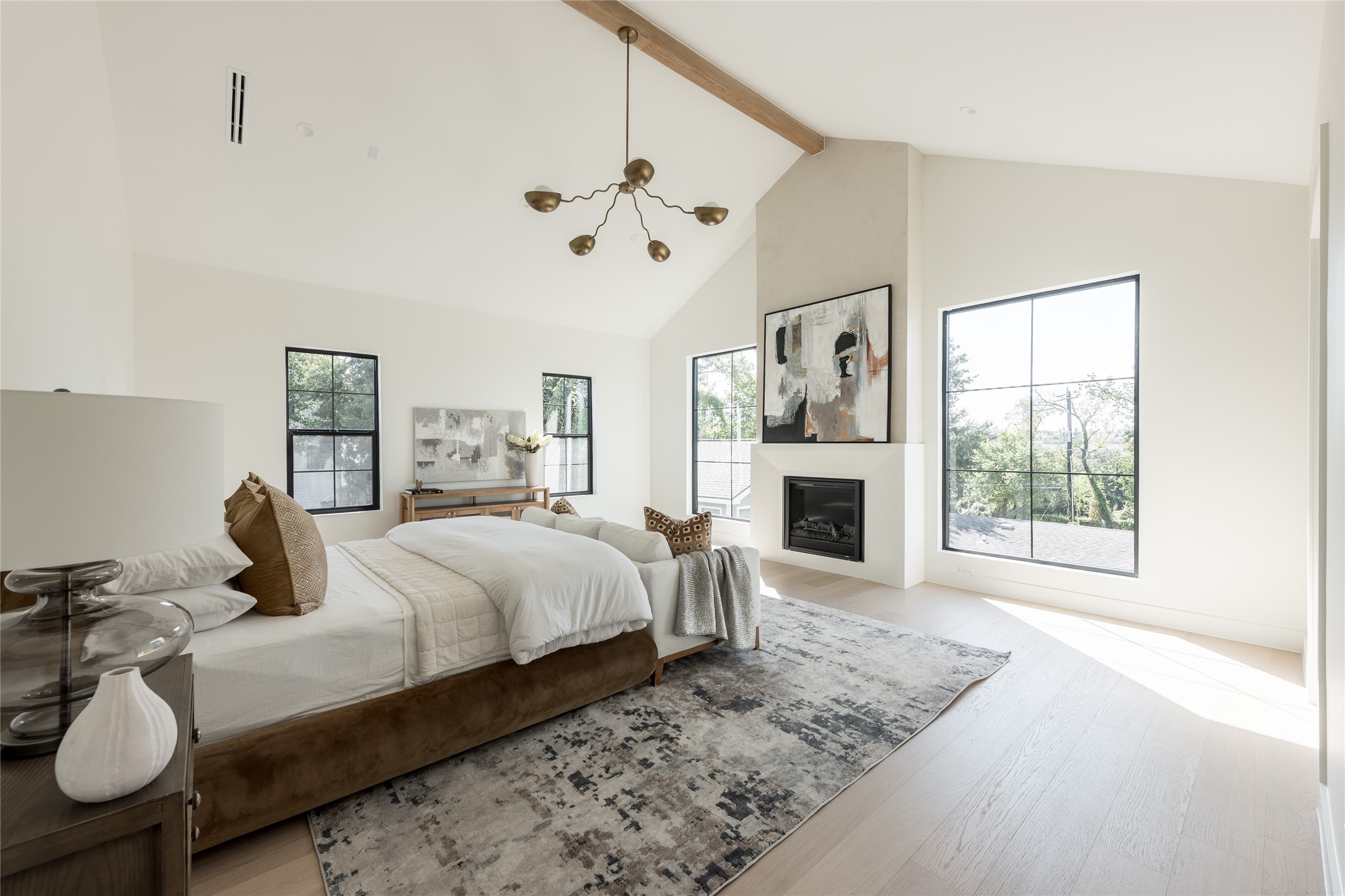A second perspective reveals the true scale of the primary suite, where the cathedral ceiling, fireplace and dedicated sitting area give the room the feel of a private residence within the home.