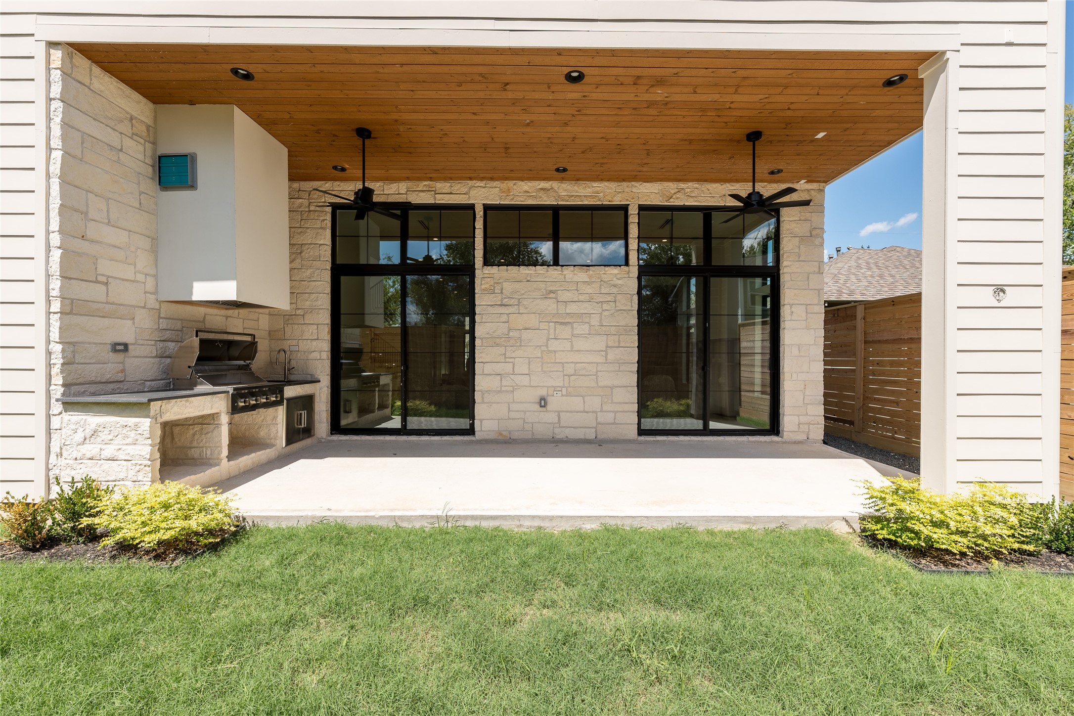 The covered rear patio extends the living experience outdoors, with a built in grill, tongue and groove ceiling and expansive dual sliding glass door systems creating a seamless connection back into the home.