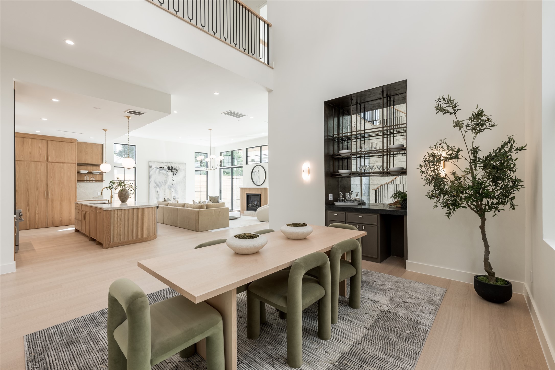 From the dining room, the homes open architecture comes into full view, connecting the two story volume to the chefs kitchen and great room while the custom white oak staircase adds a sculptural element of its own.