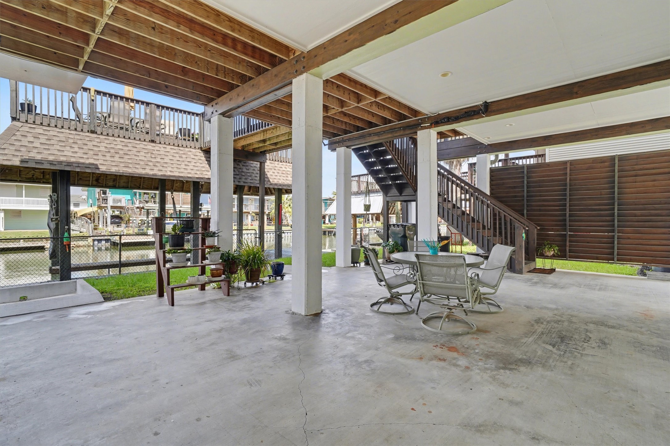 Downstairs open area designed as the heart of waterfront living, offering generous space for outdoor dining and a large sectional sofa. Perfect for entertaining, relaxing, and enjoying the coastal breeze, this inviting space captures the essence of life by the water