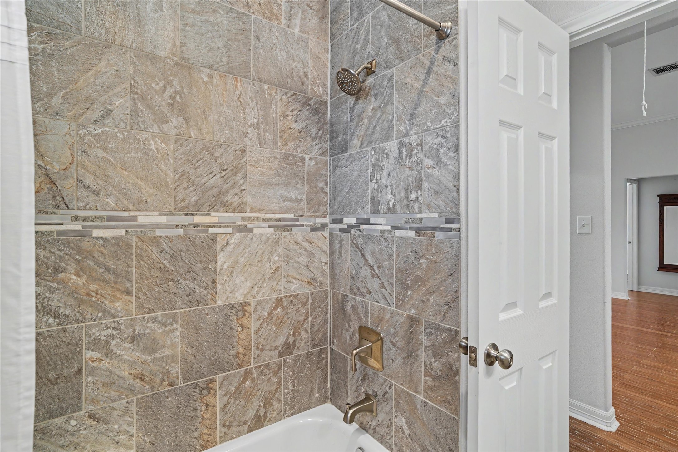 The custom tiled shower/tub is perfect for those who want a tub or have small children needing a tub. Notice the detail tile work
