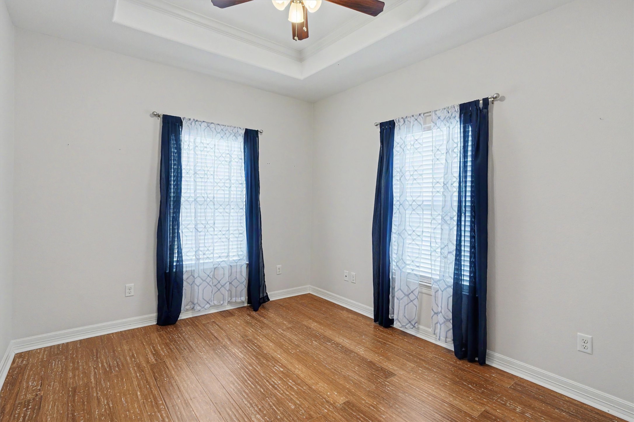 Guest bedroom with plenty of room for bedroom furnishings. The trayed ceiling is a night touch. The home is awash with natural sunlight
