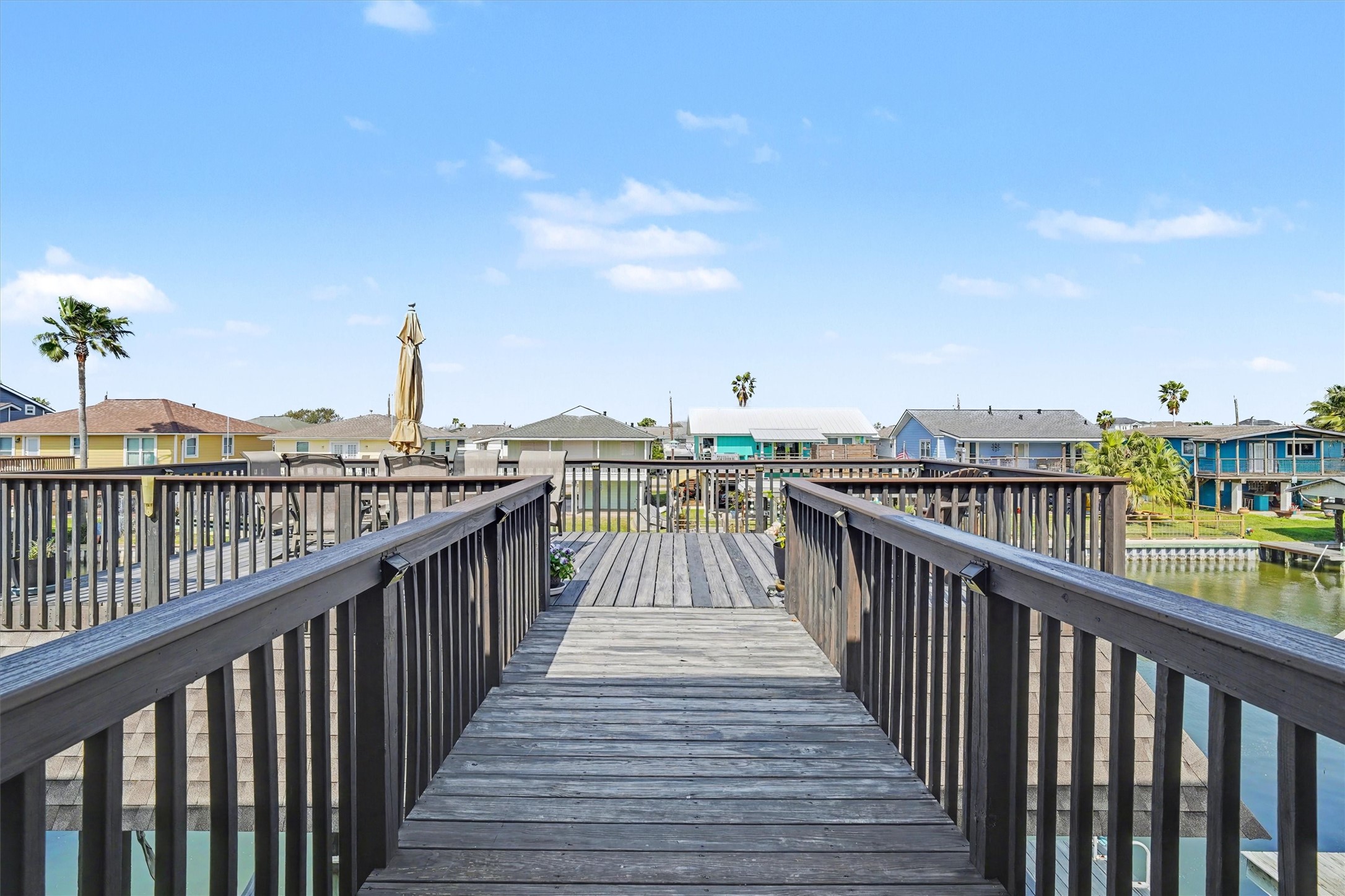 Catwalk leads to the upper party deck, a vibrant space perfect for entertaining, outdoor dining, or quiet moments with a good book. Enjoy sweeping views and the peaceful sight of pelicans gliding byan ideal retreat for relaxation and coastal living