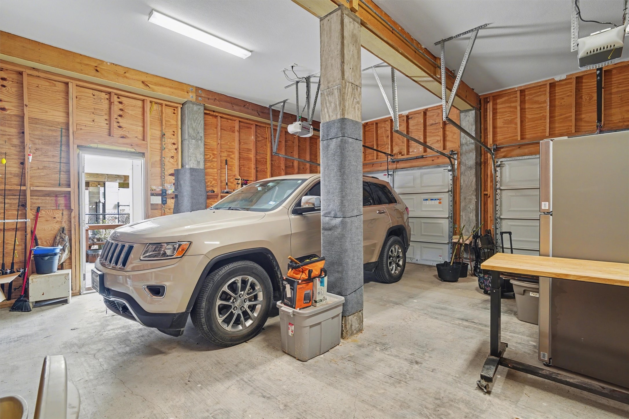 Oversized double garages offering exceptional space for vehicles, a golf cart, boat trailer, or additional storage. Thoughtfully designed for convenience and versatility, this area provides ample room to organize, protect, and enjoy all the essentials of waterfront living