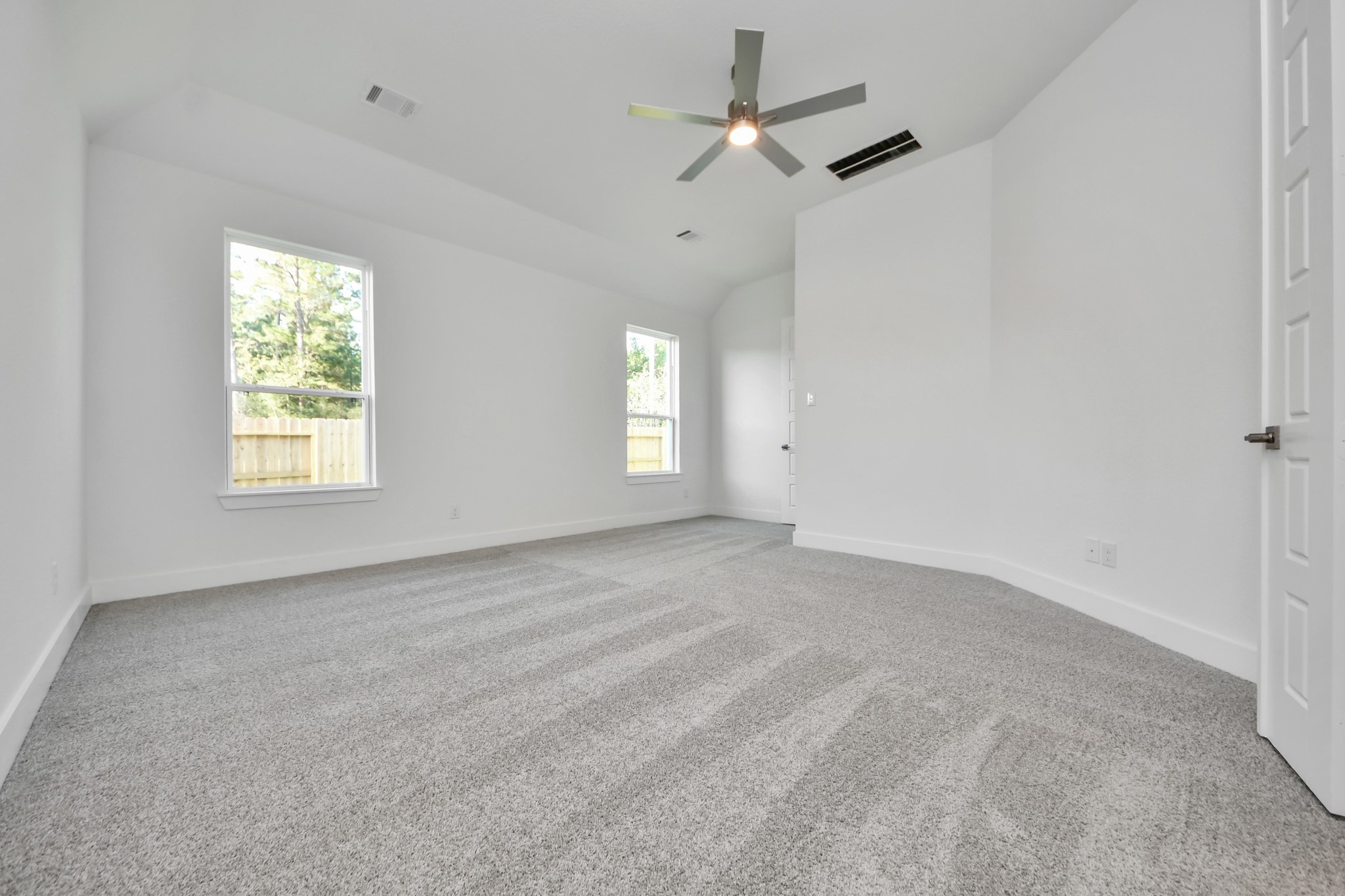 Escape to tranquility in this spacious primary room, adorned with plush carpeting and bathed in the soothing hues of warm paint colors, creating a cozy retreat for relaxation.