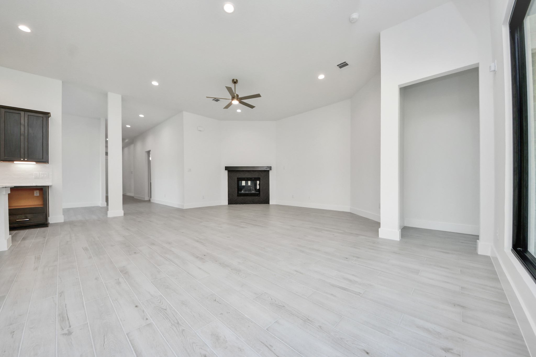 Gather the family and guests together in your lovely living room! Featuring soaring high ceilings, recessed lighting, ceiling fan, custom paint, gorgeous floors, and large windows that provide plenty of natural lighting throughout the day.