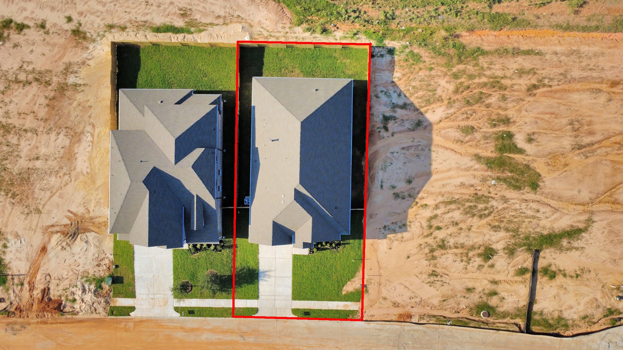 An aerial view of a spacious subdivision lot, highlighting a well-maintained yard and a fully fenced perimeter, offering both privacy and expansive outdoor space.